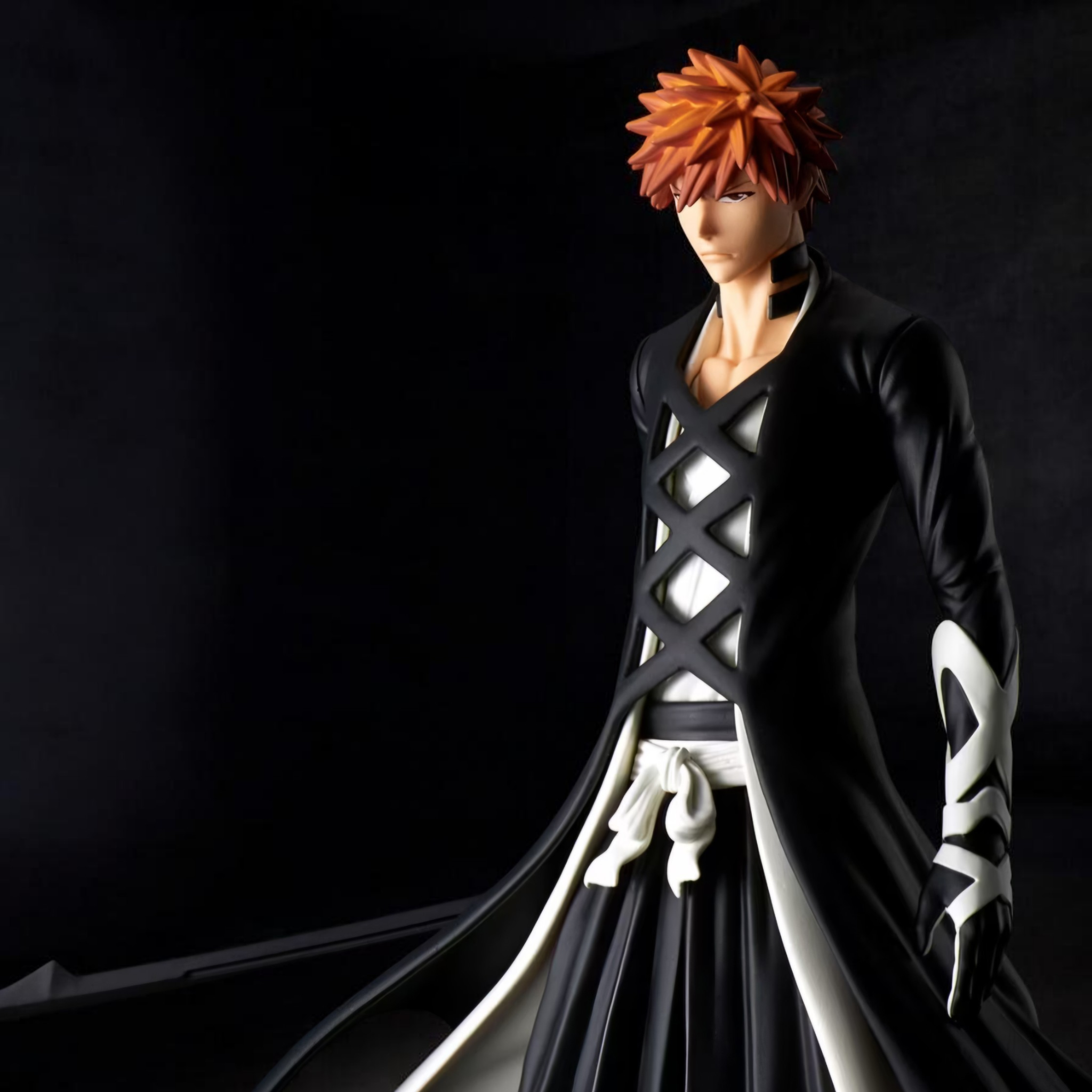 Figurine of a character with orange hair and black outfit on a dark background