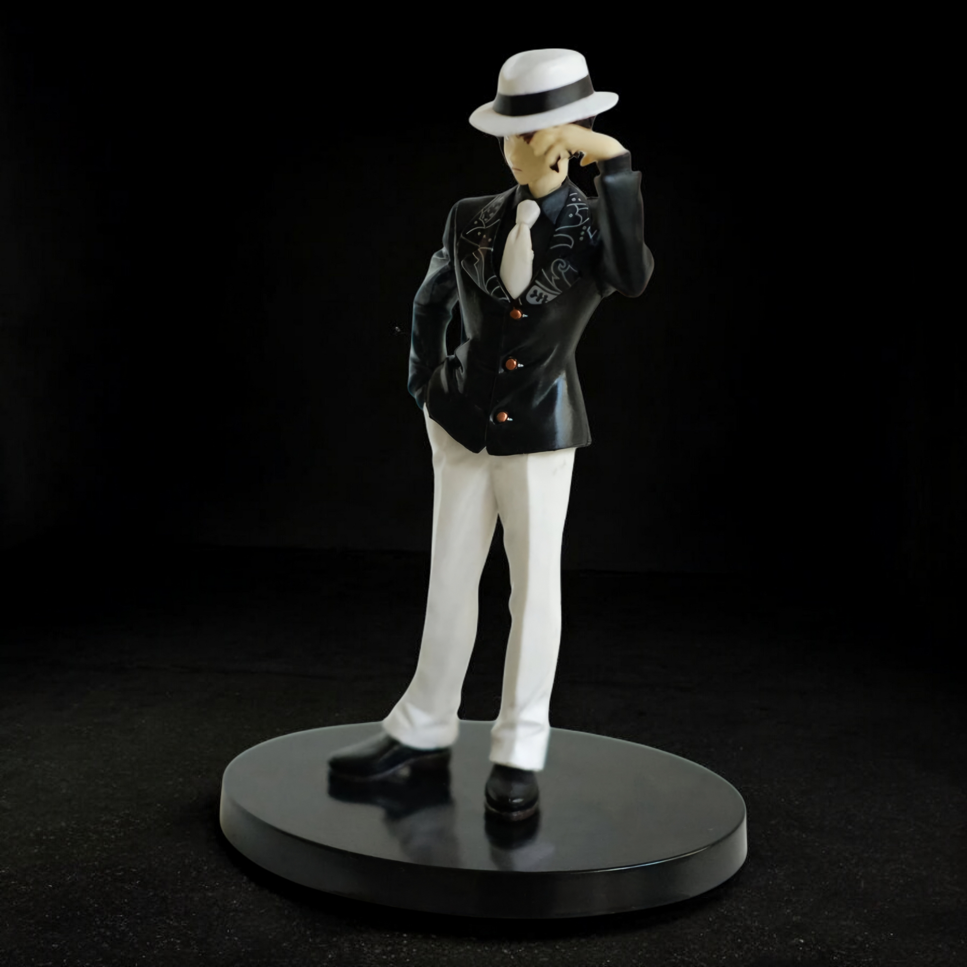 Figurine of a character in a suit and hat on a black background