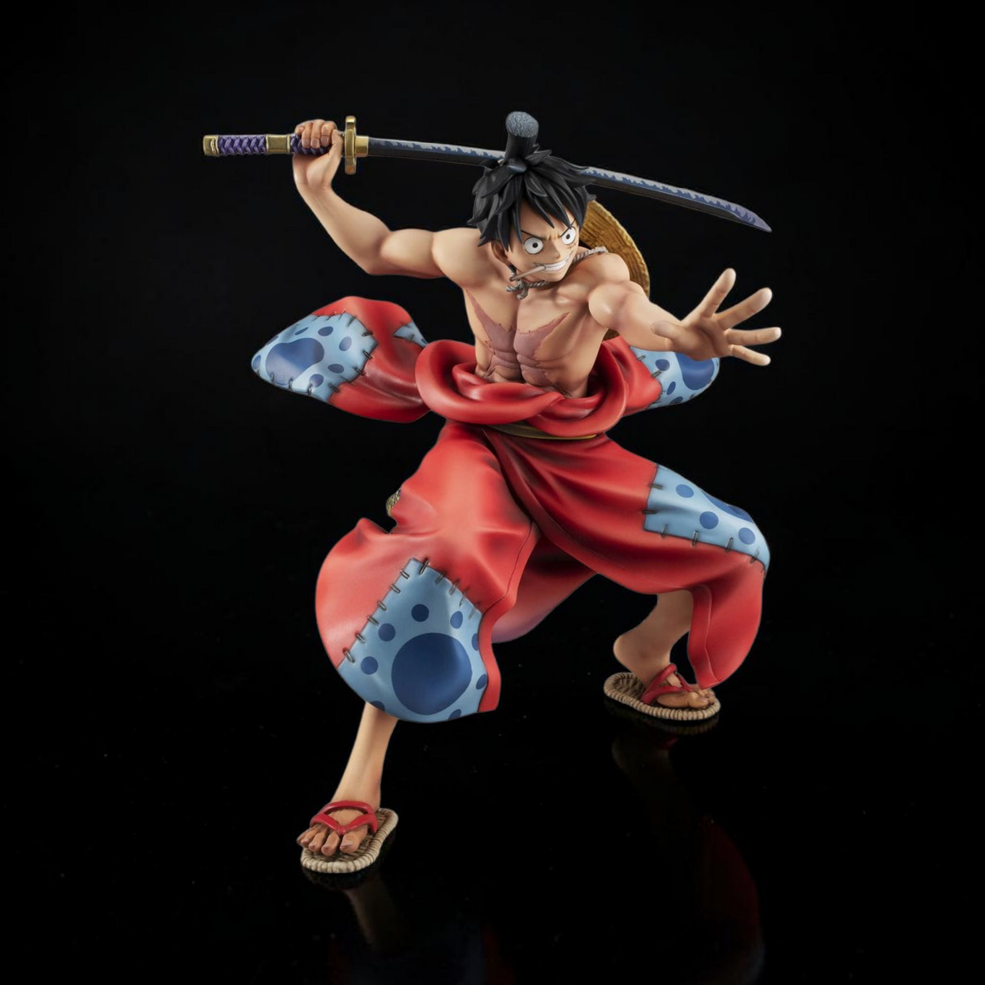 Action figure of a character in red and blue attire with a sword on a black background