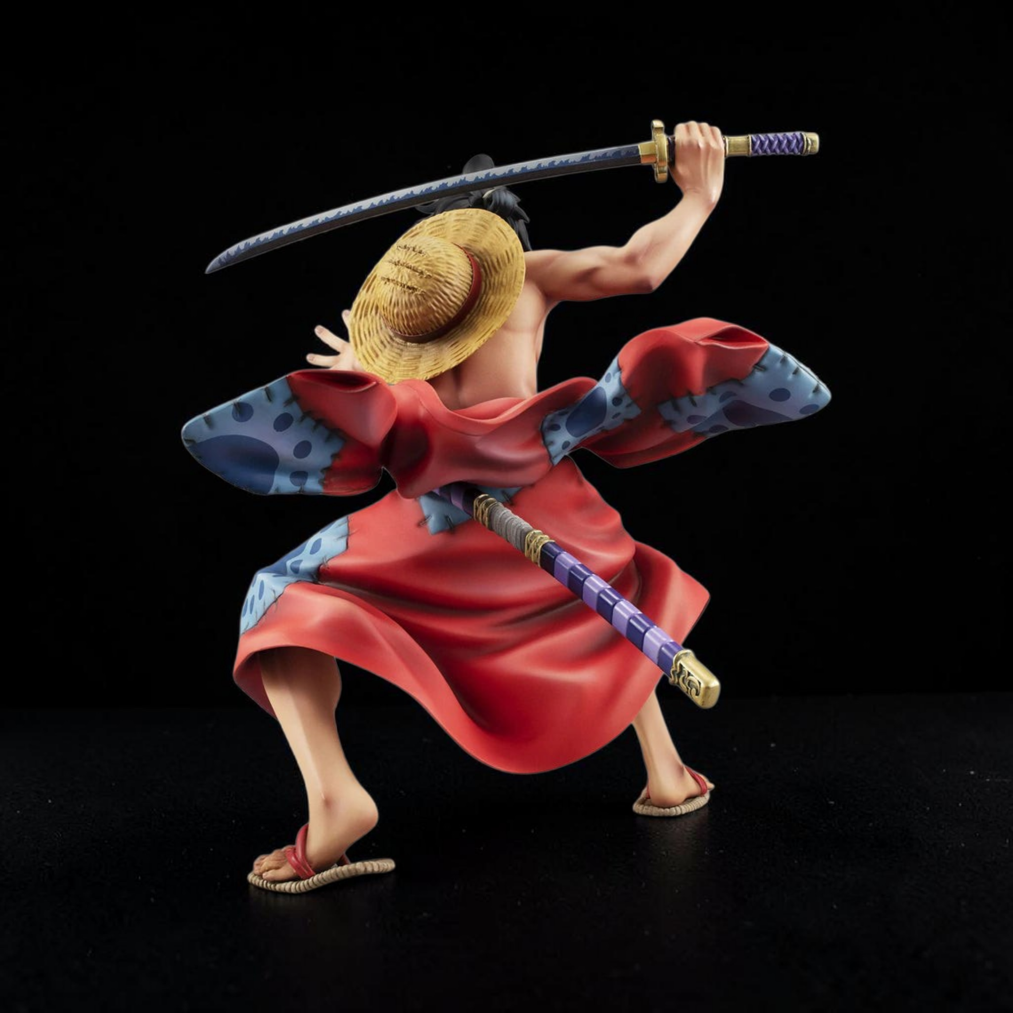 Figurine of a character from a popular anime series with a sword on a black background
