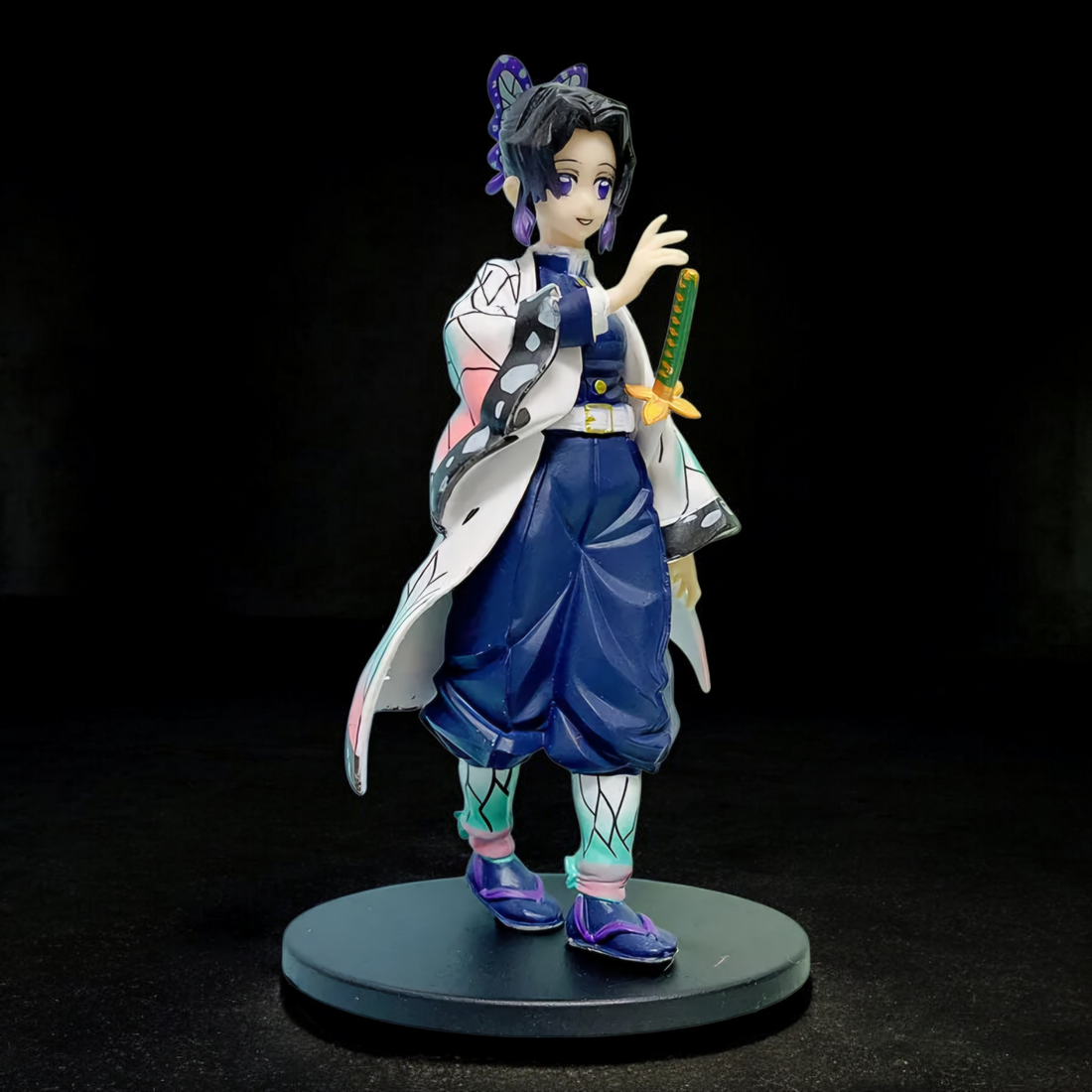 Anime character figurine in a garden with wisteria flowers and a pond.