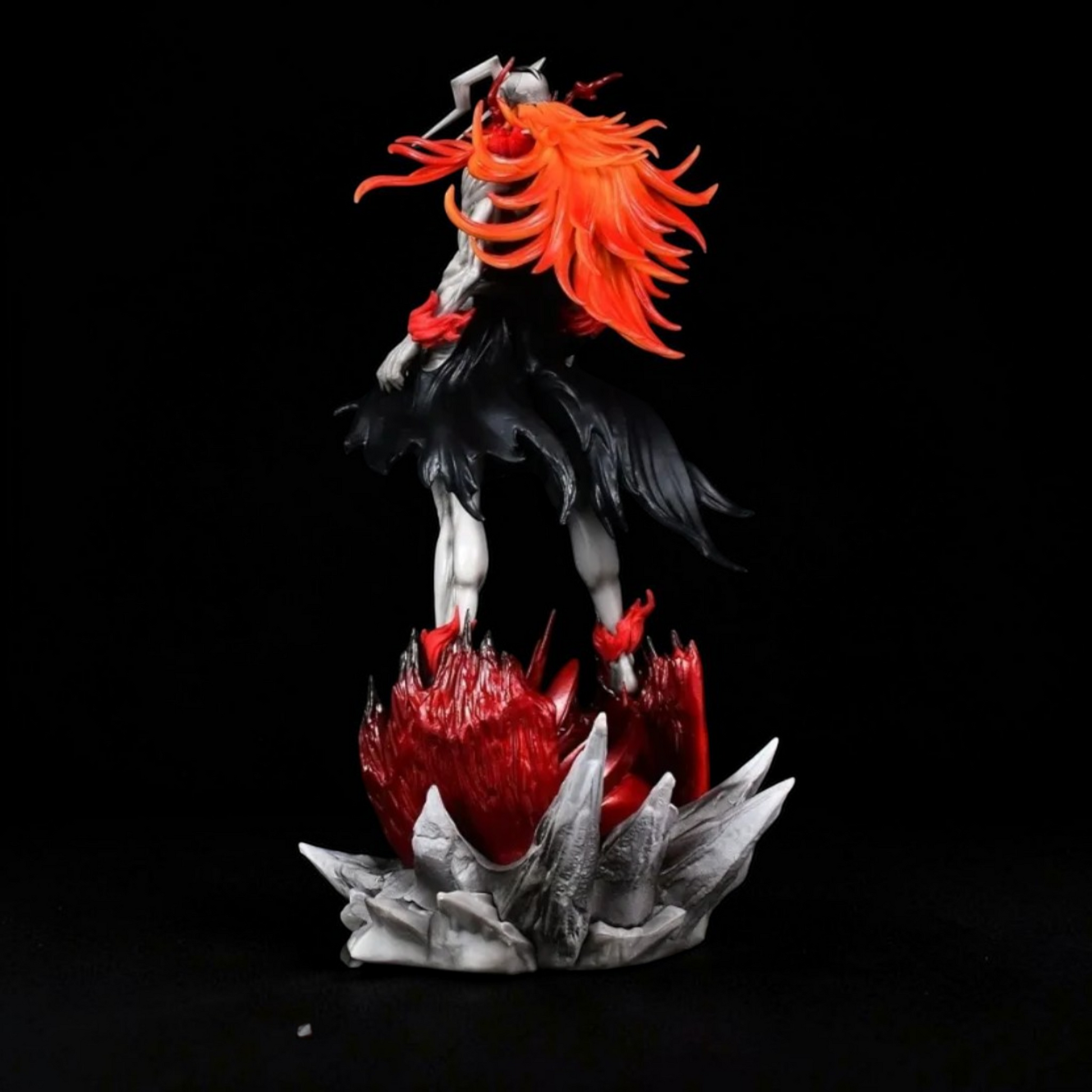 Statue of a character with red hair and black outfit on a dark background