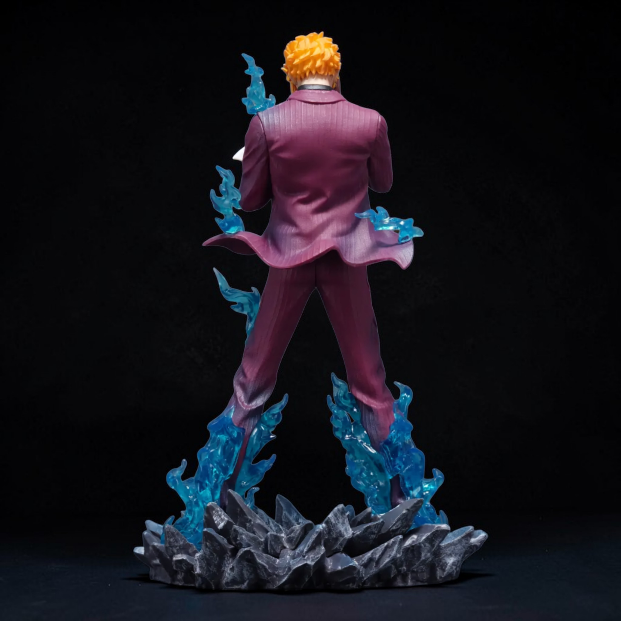 Figurine of a character in a pink suit with blue accents on a dark background
