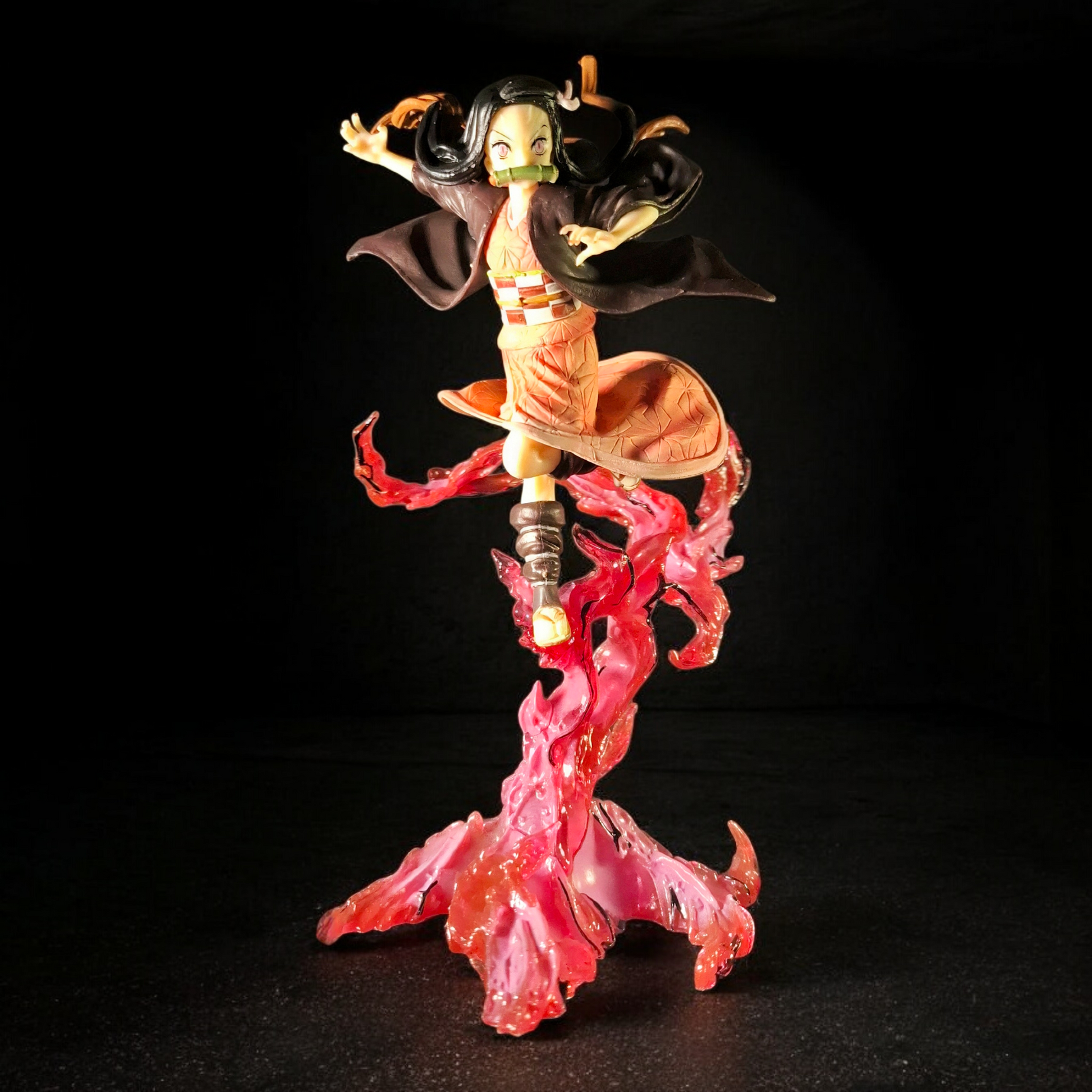 Figurine of a character with black hair and red flames on a black background