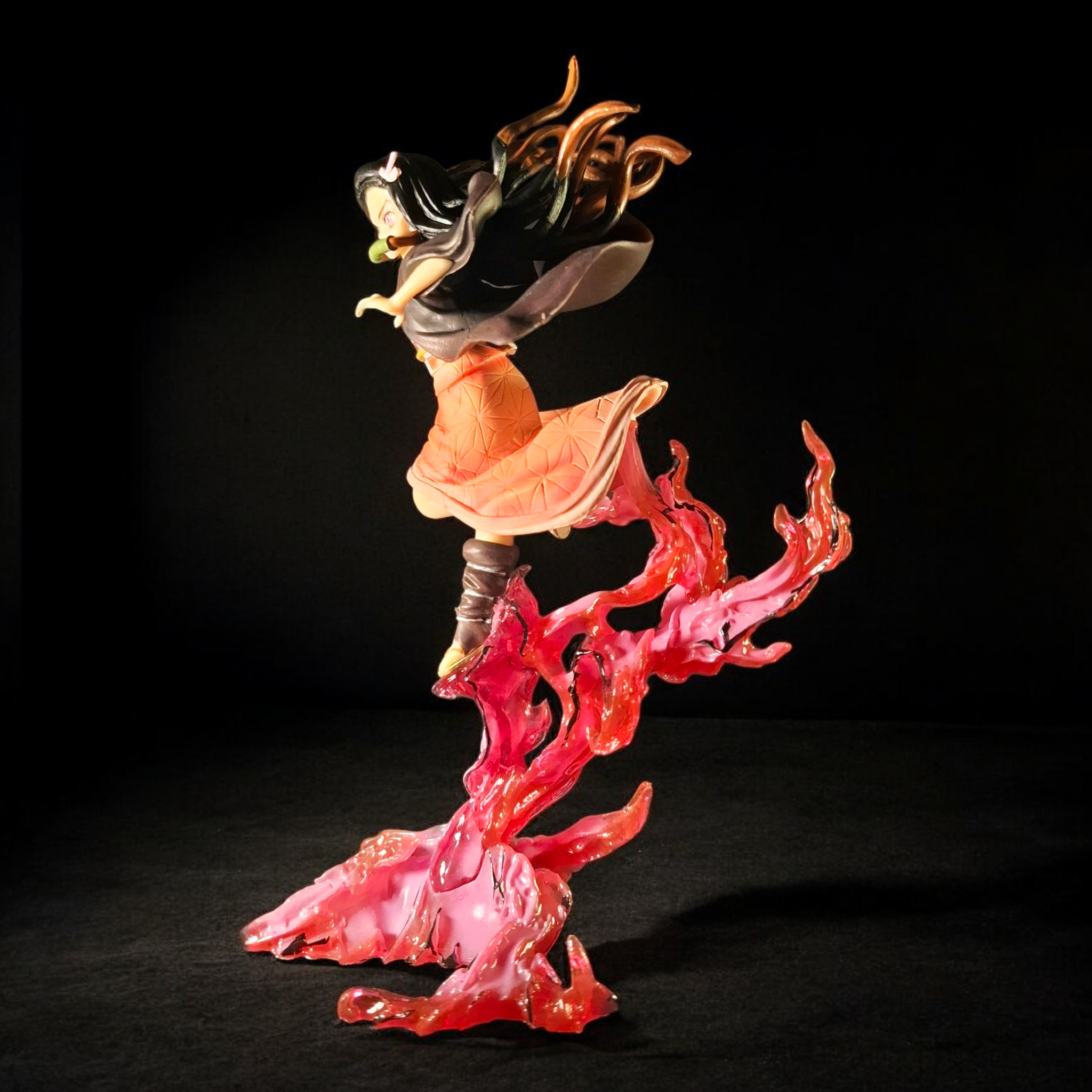 Figurine of a character with black hair and red flames on a black background