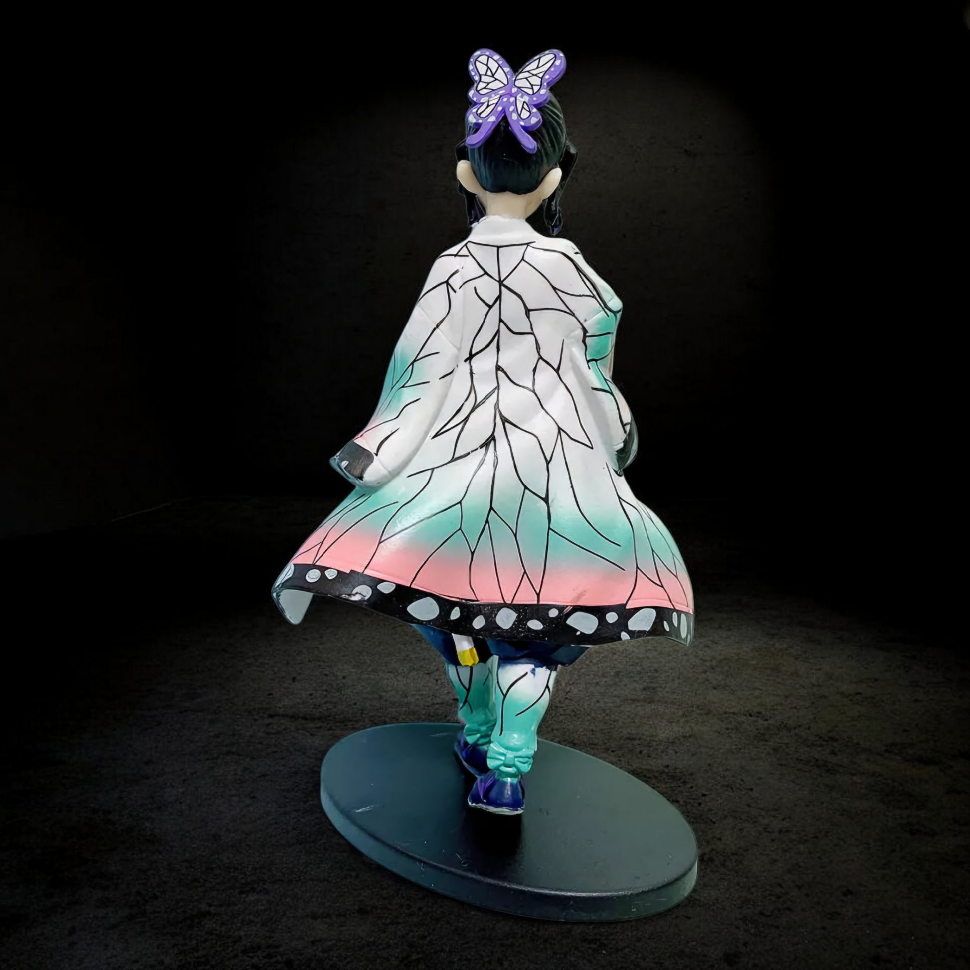 Figurine with a colorful dress and butterfly accessory on a dark background