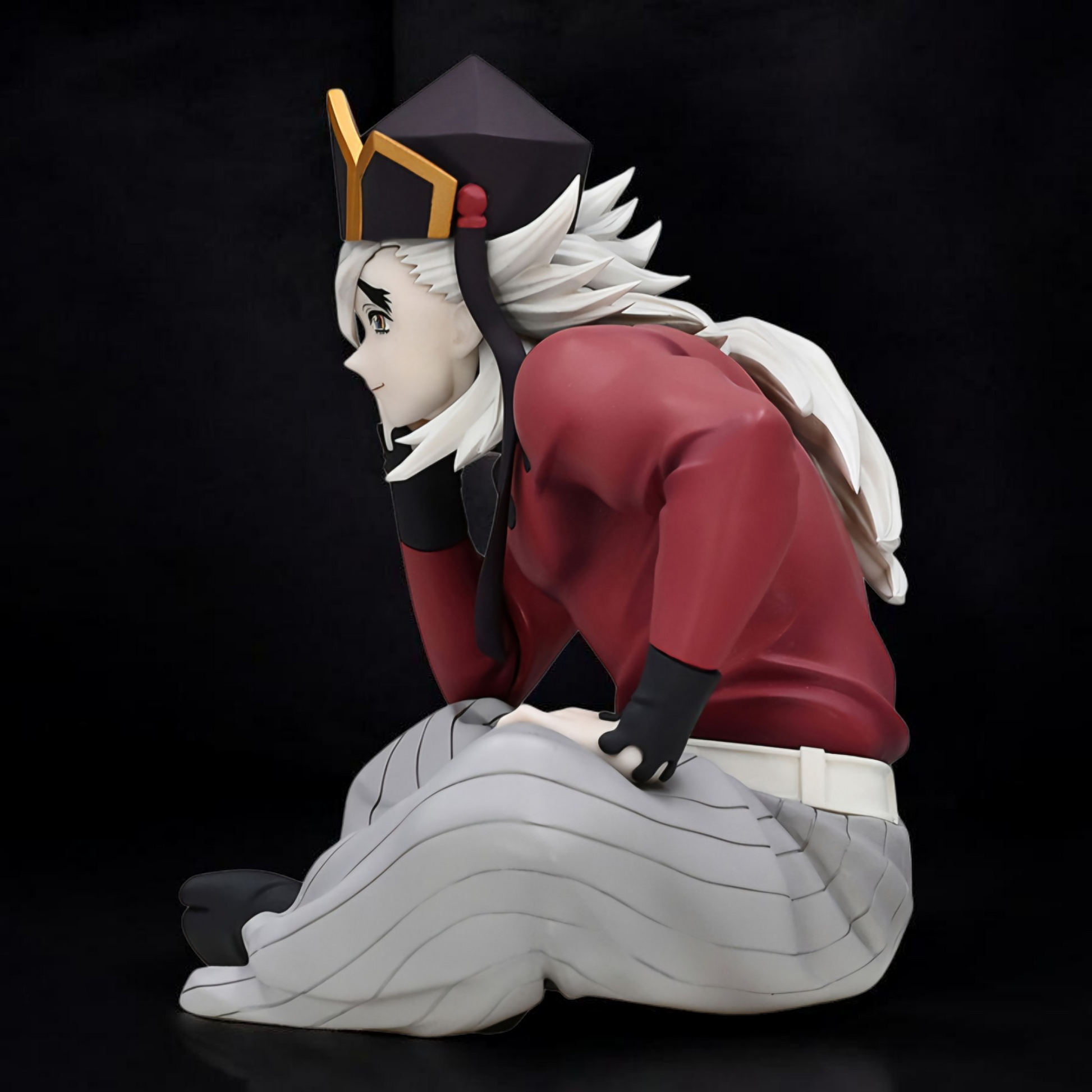 Anime character figurine with red outfit and white hair on a black background