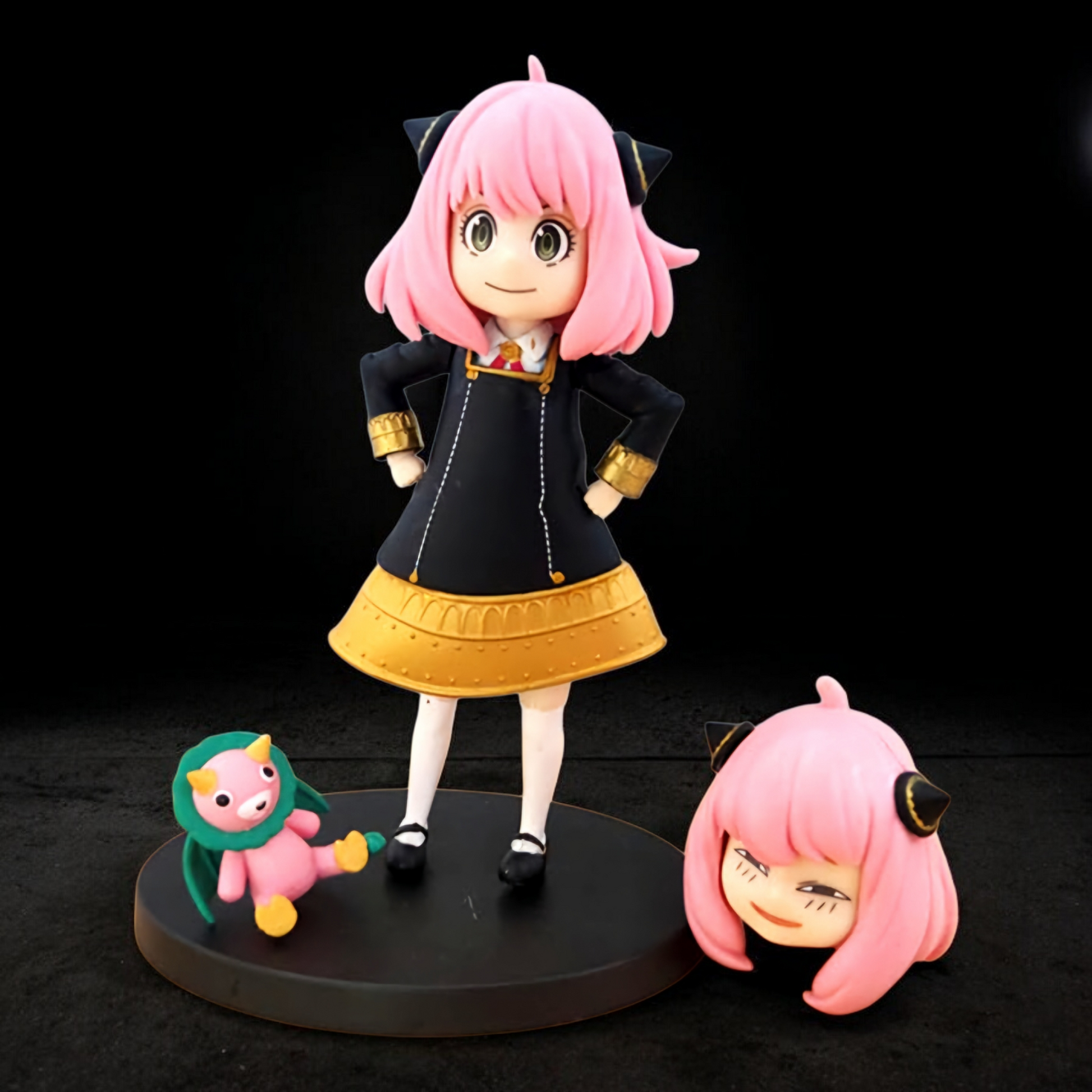 Anime character figurine with pink hair and black and gold outfit on a black background