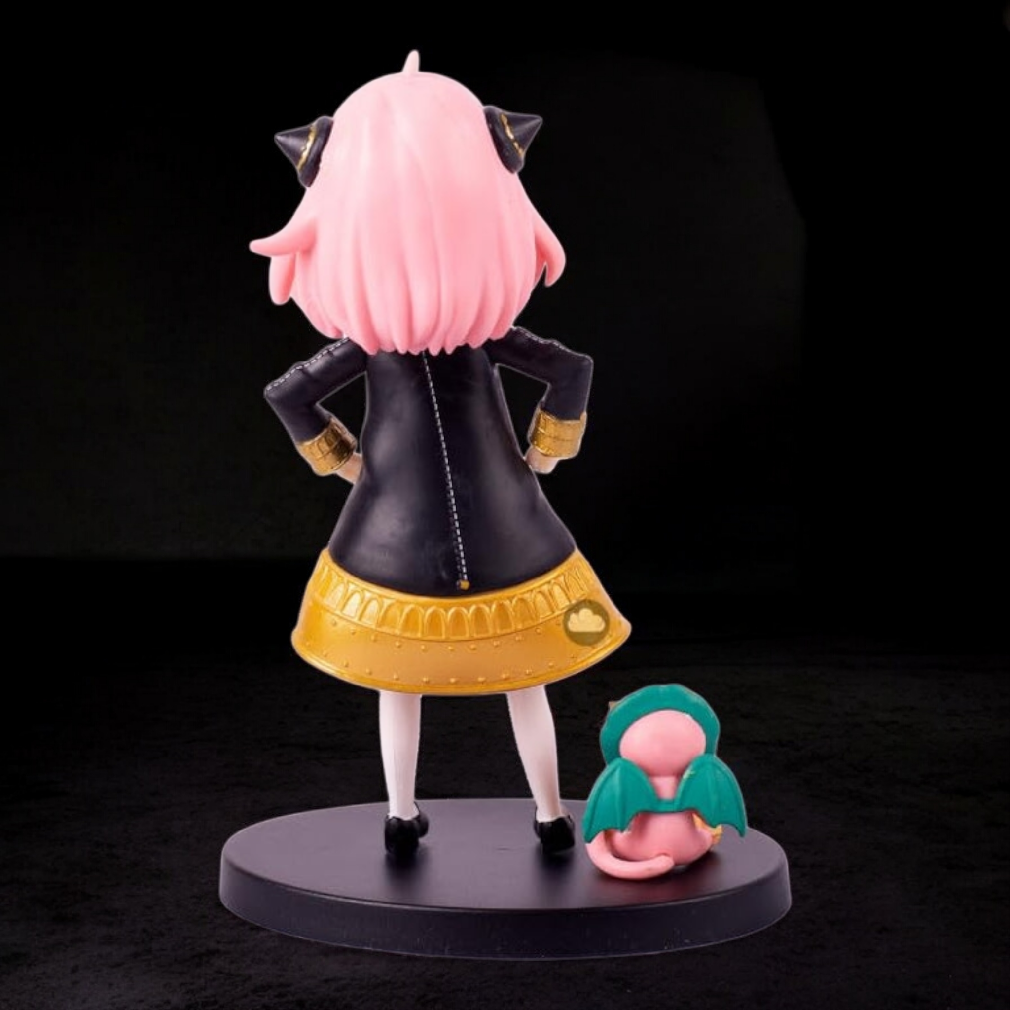 Figurine with pink hair and black and yellow outfit on a dark background