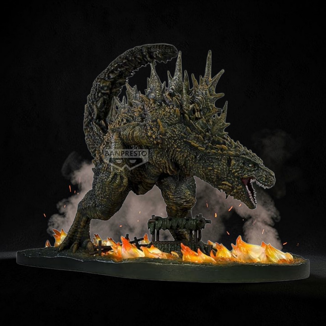 Model of Godzilla with flames at its feet on a dark background