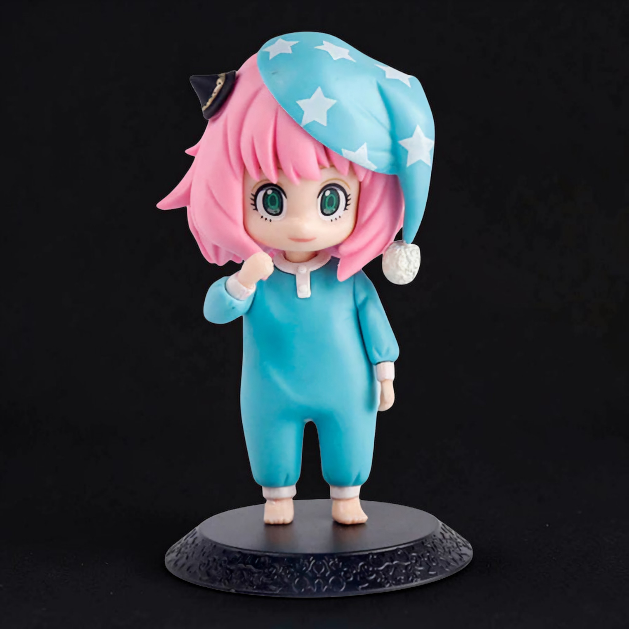 Figurine of a character with pink hair and a blue outfit on a black background