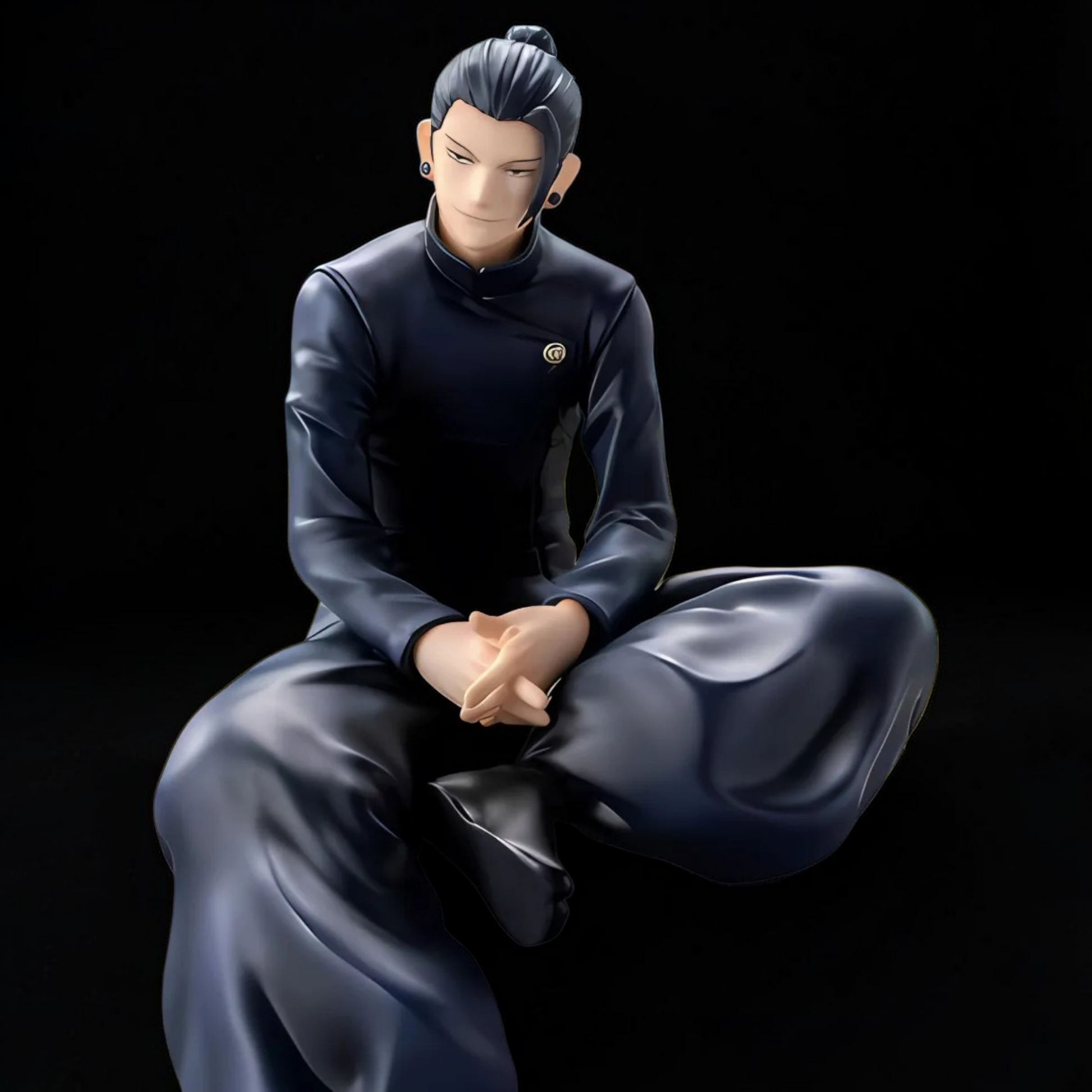 Statue of a person in a dark outfit sitting with hands clasped on a black background