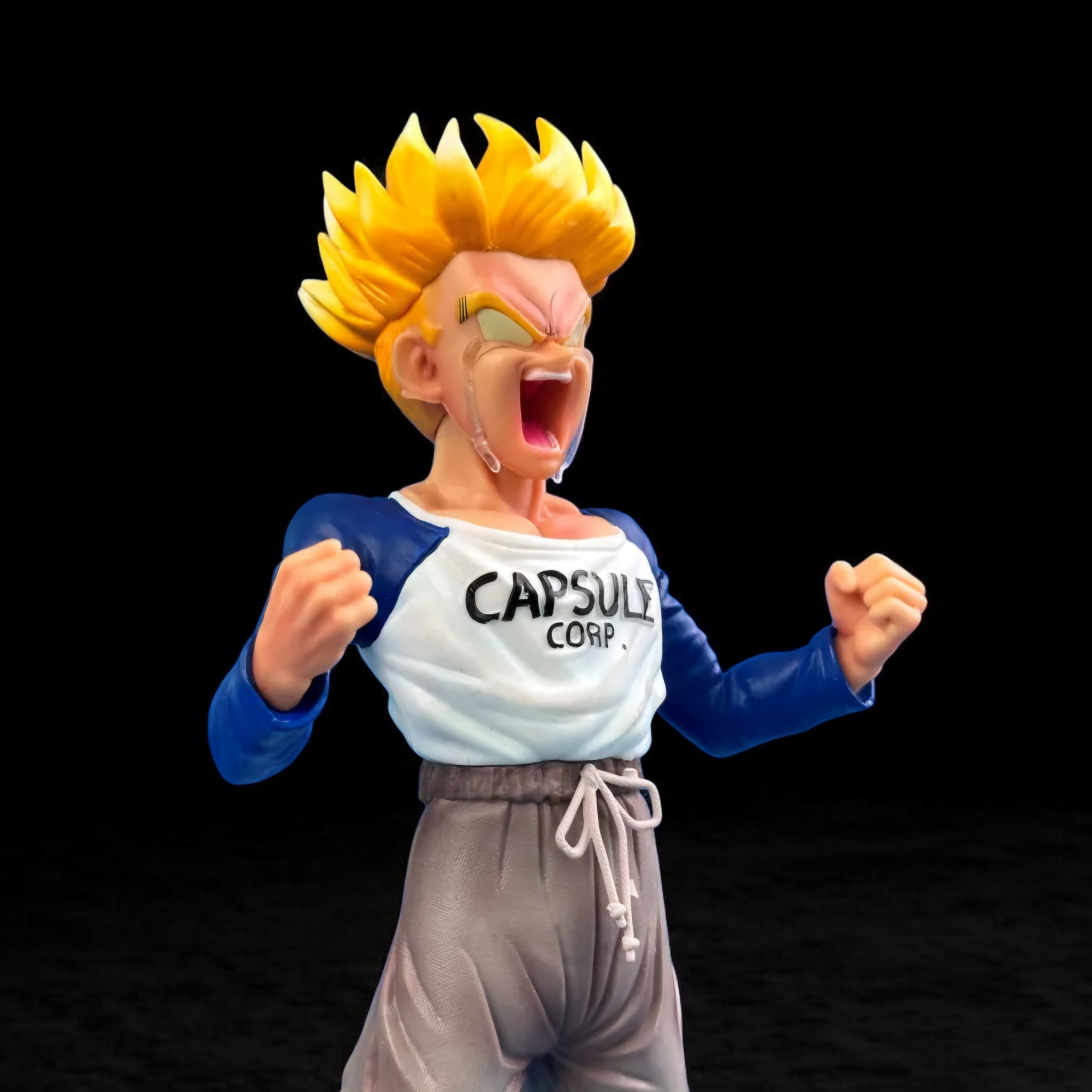 Action figure wearing a 'Capsule Corp.' shirt on a black background