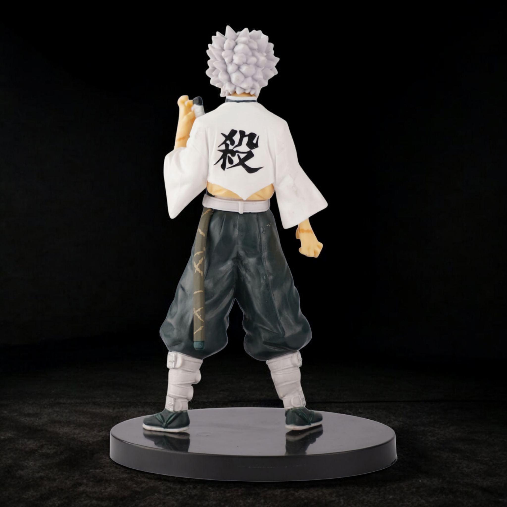 Figurine of an animated character with white hair and traditional outfit on a black background