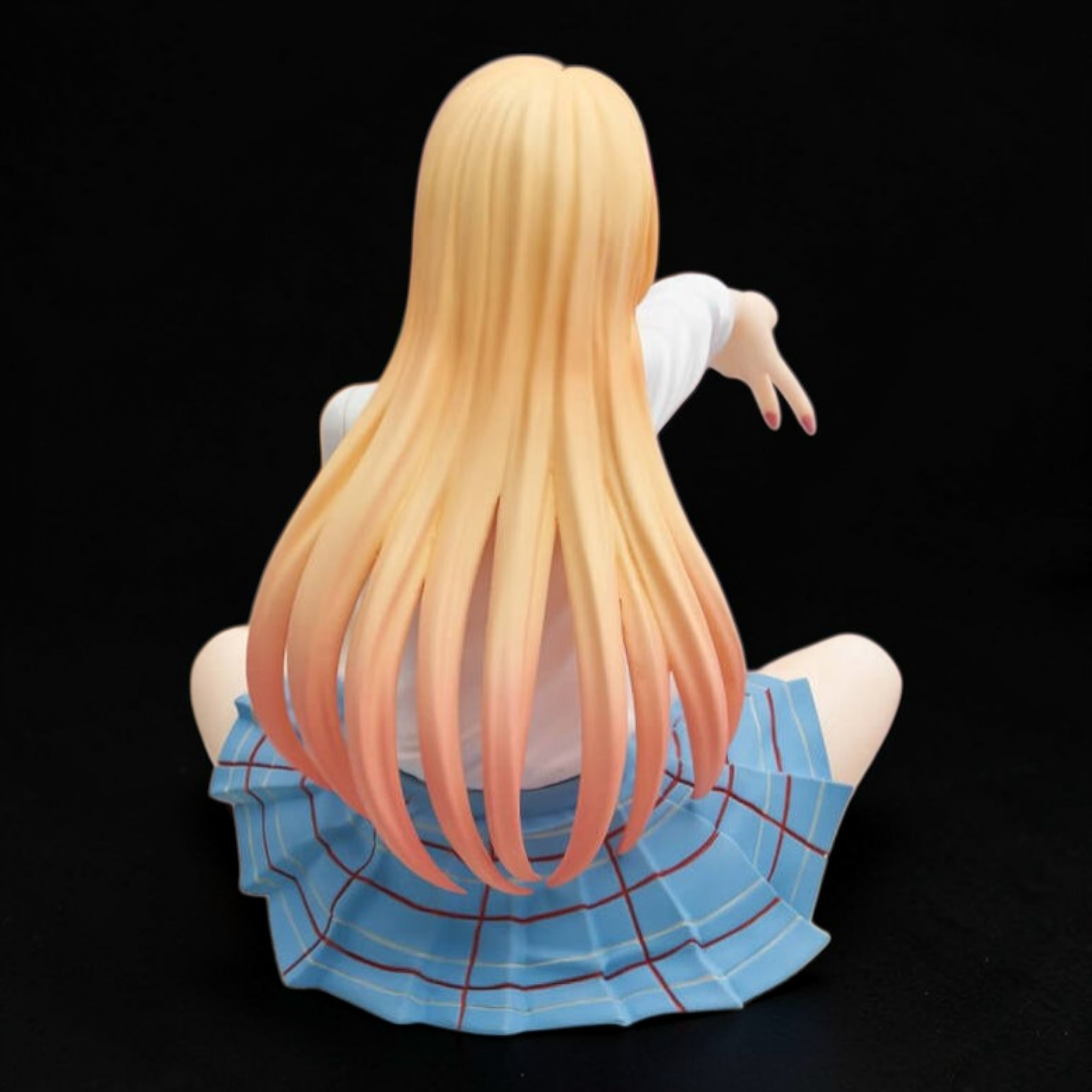 Figurine of a character with long blonde hair and a blue skirt on a black background