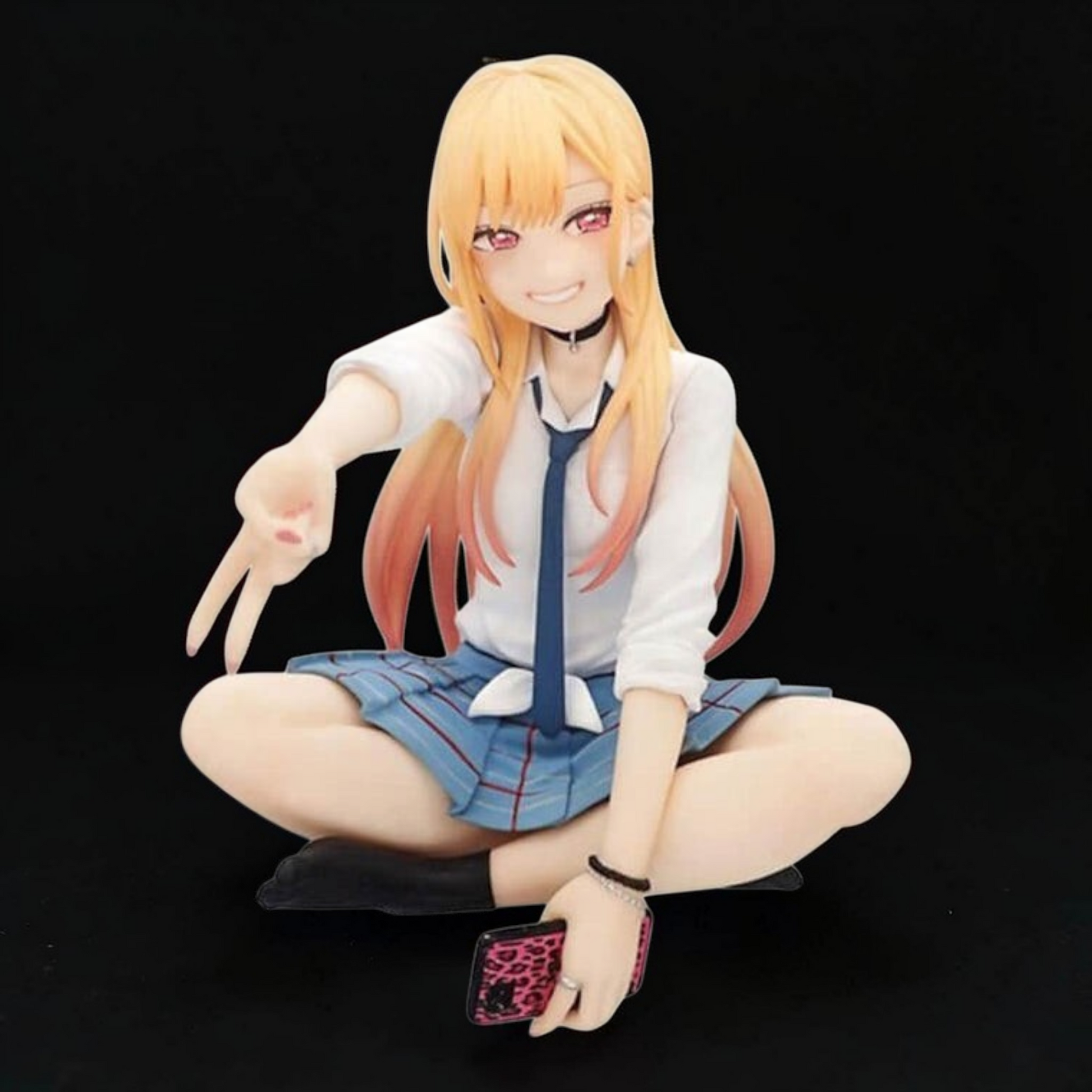 Anime character figurine sitting cross-legged on a black background