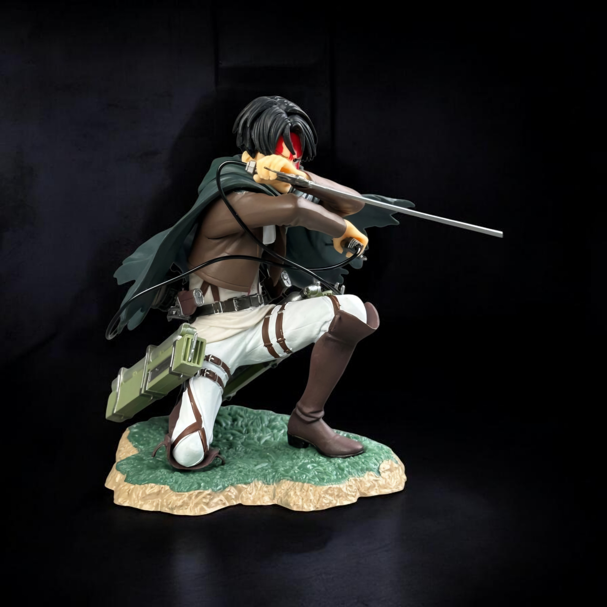 Statue of a character with a bow and green cape on a dark background