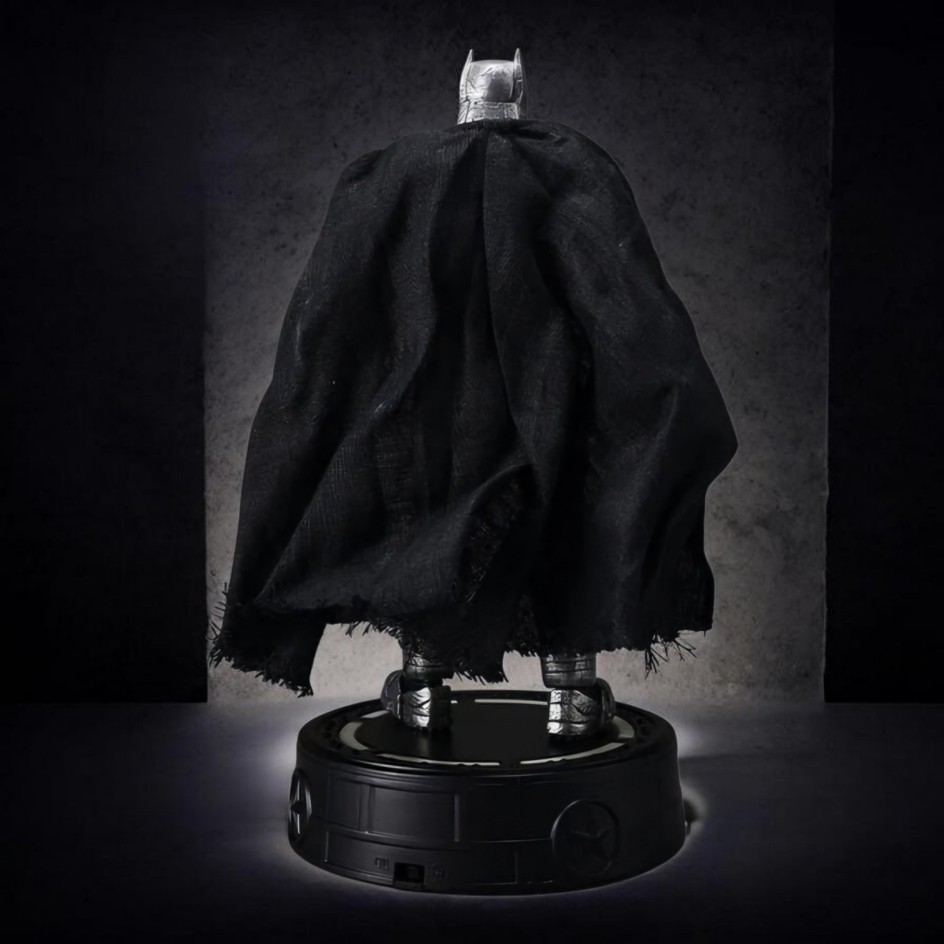 Batman figure with cape on a dark background