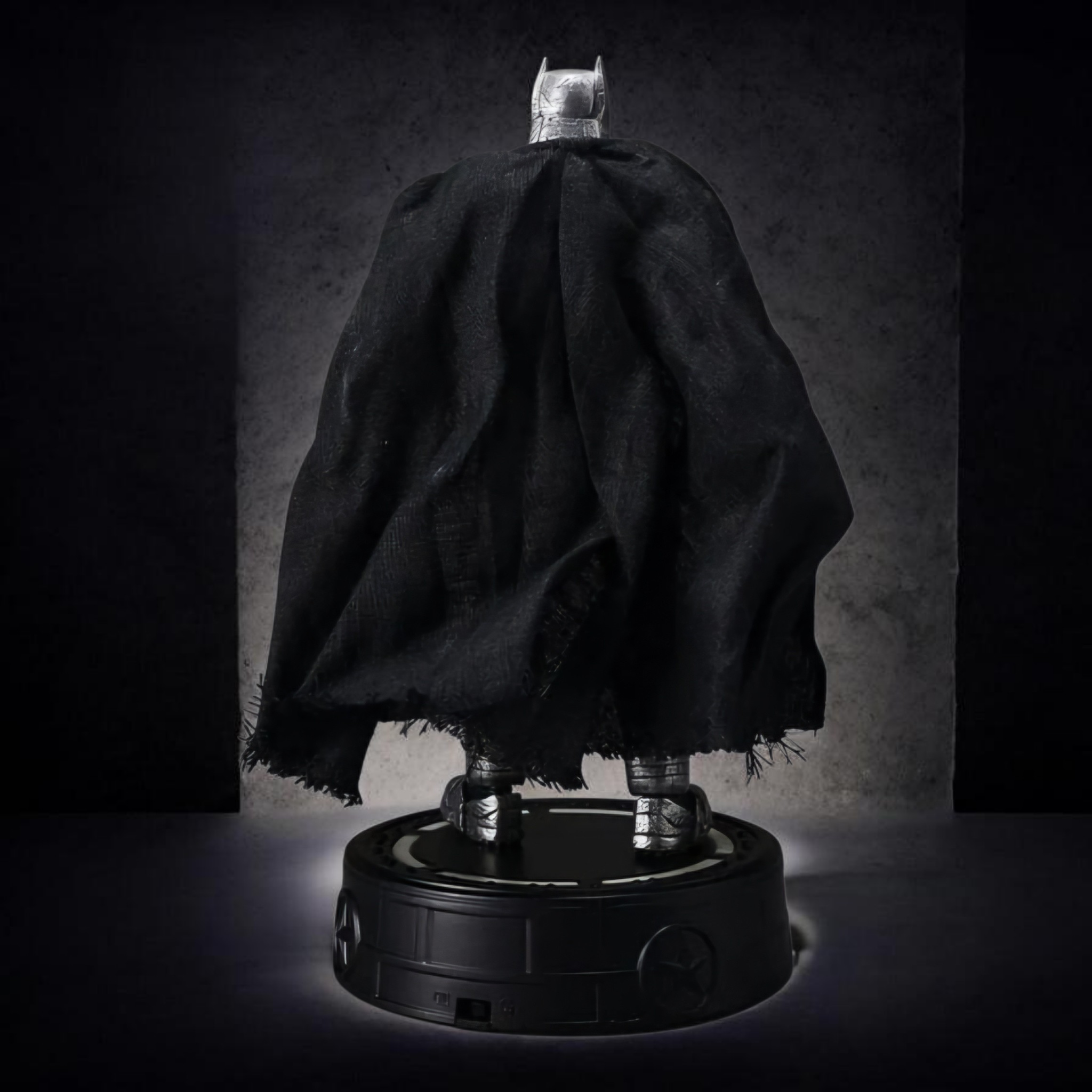 Batman figure with cape on a dark background