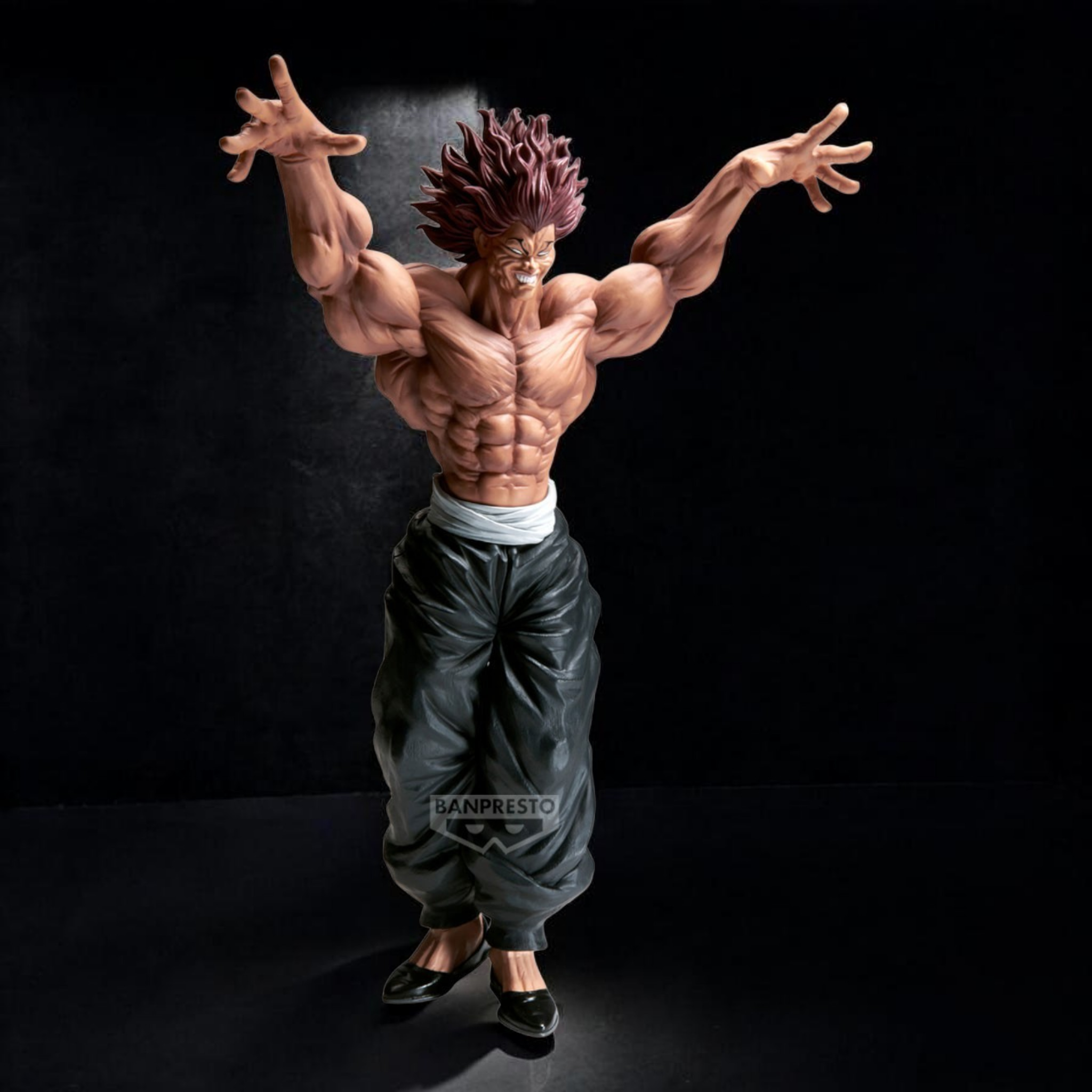 Action figure of a muscular character with outstretched arms on a black background