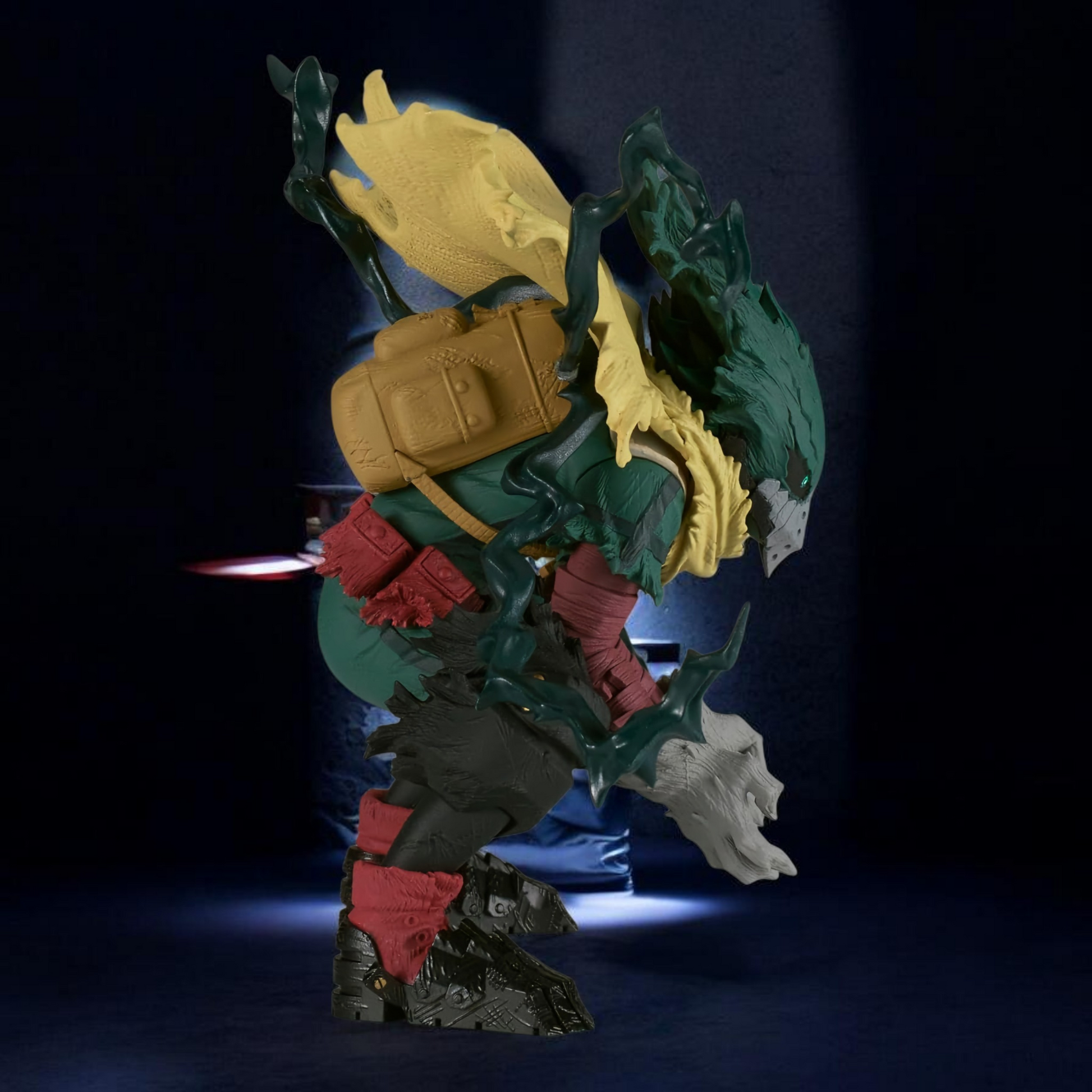 Toy figure of a green and yellow creature with red accents on a dark background