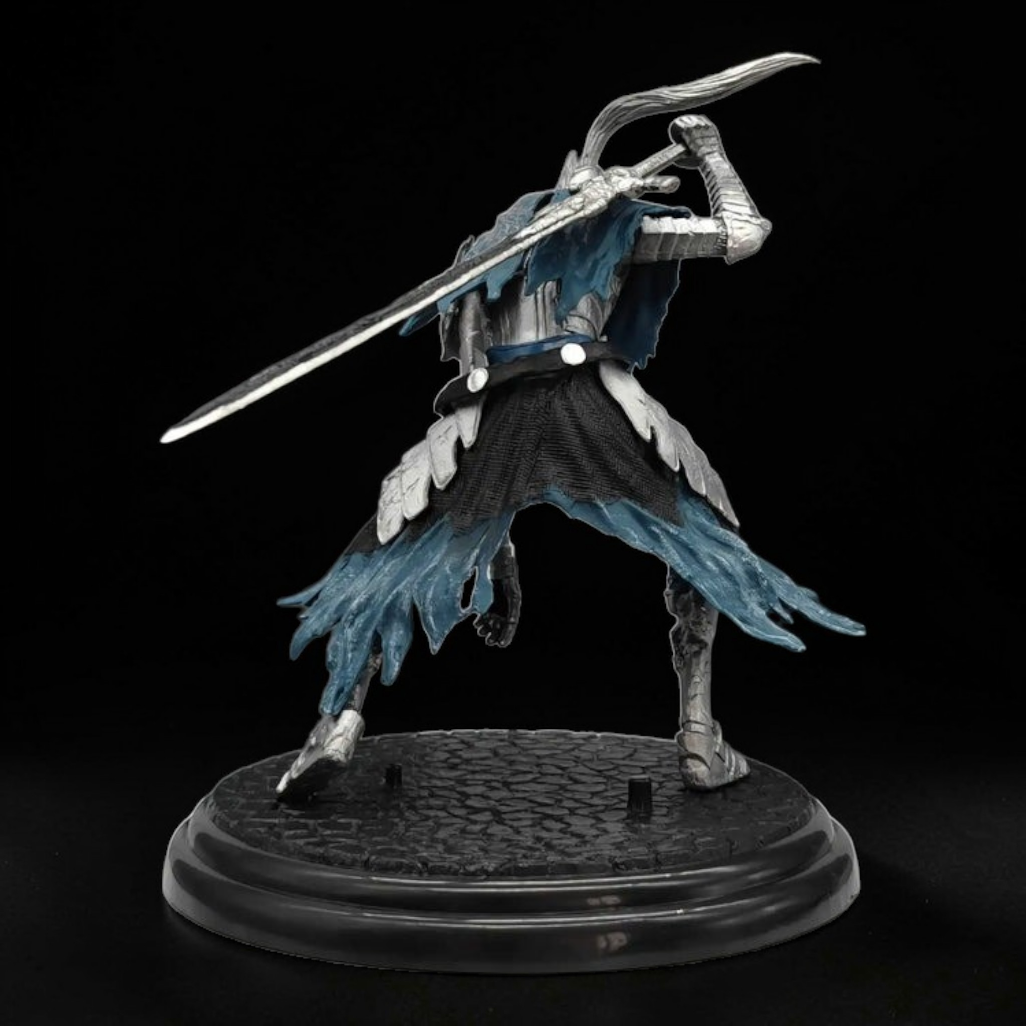 Figurine of a character with a sword on a black background