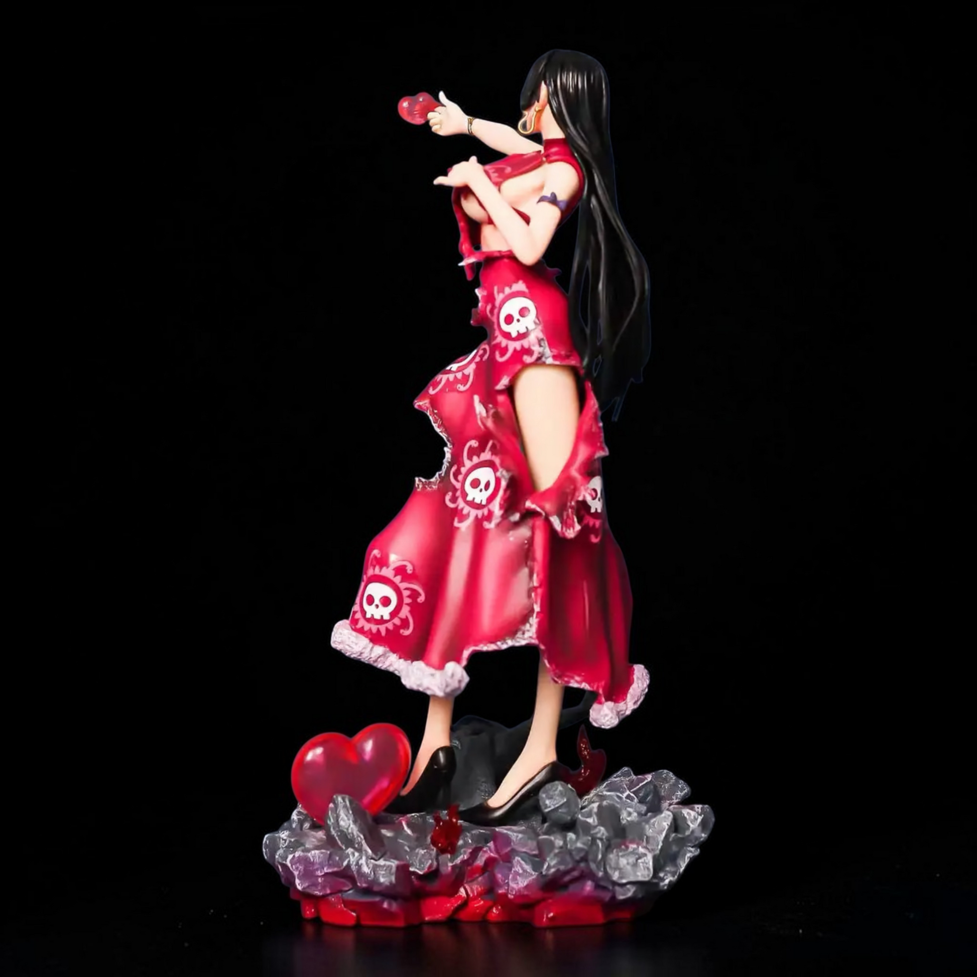 Figurine of a character in a red dress with skull designs on a black background