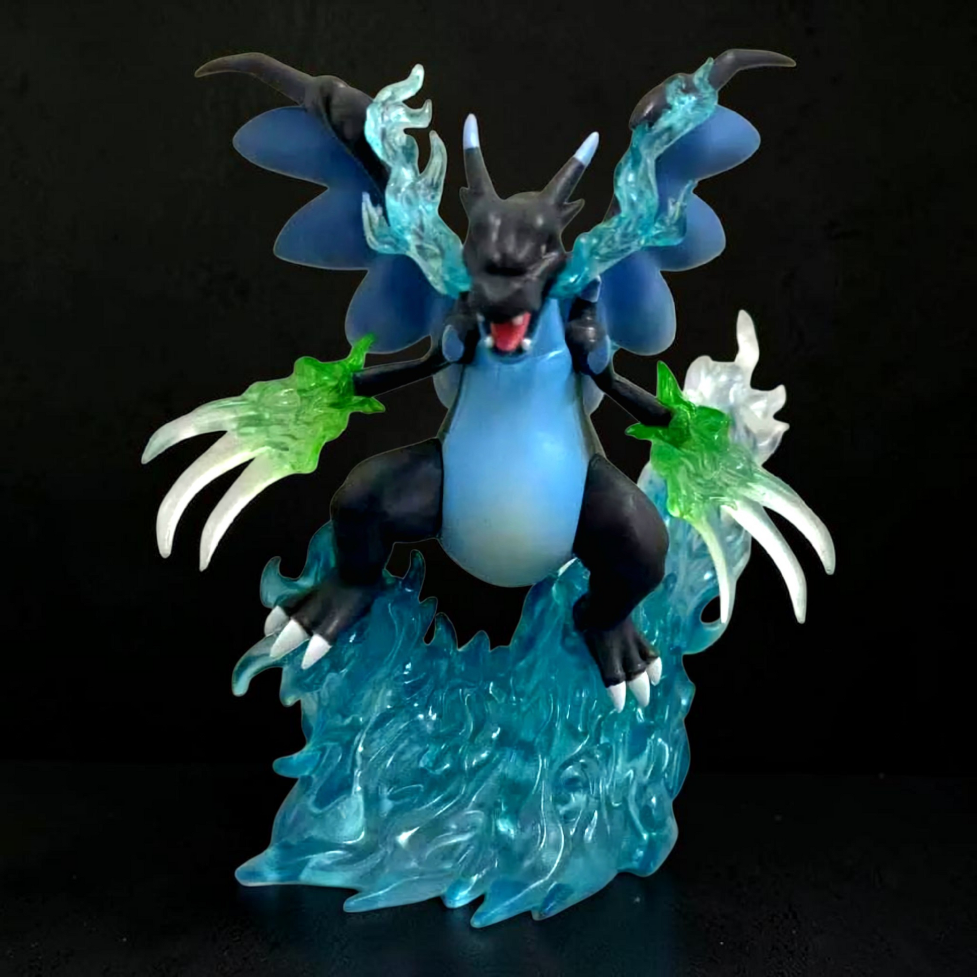 Dragon-like creature figurine with blue and green accents on a black background