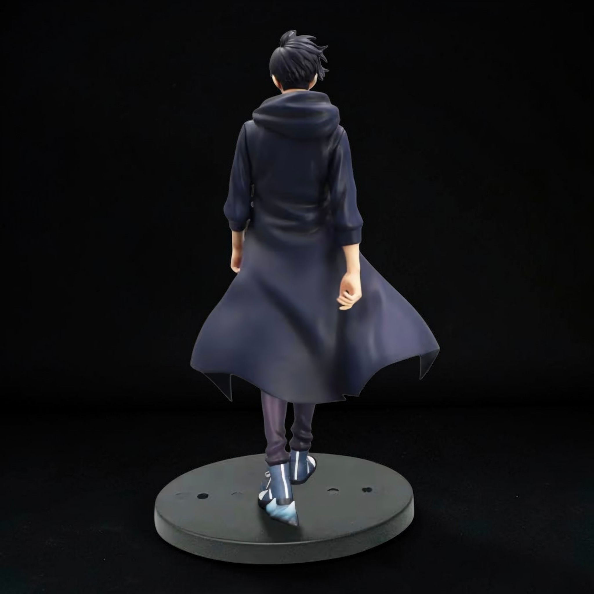Figurine of a character in a long coat on a black background