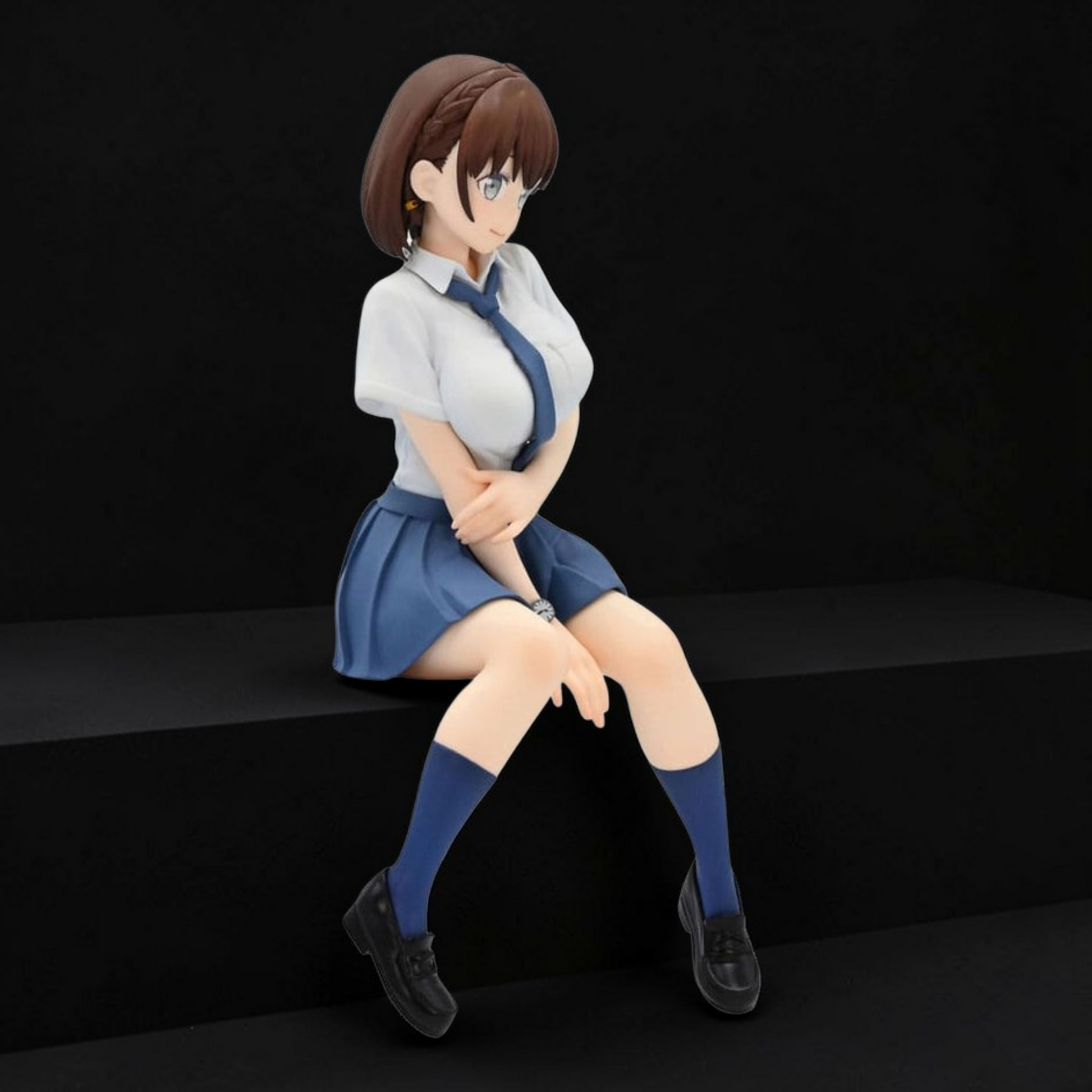 Figurine of a character in a school uniform sitting on a black surface with a dark background