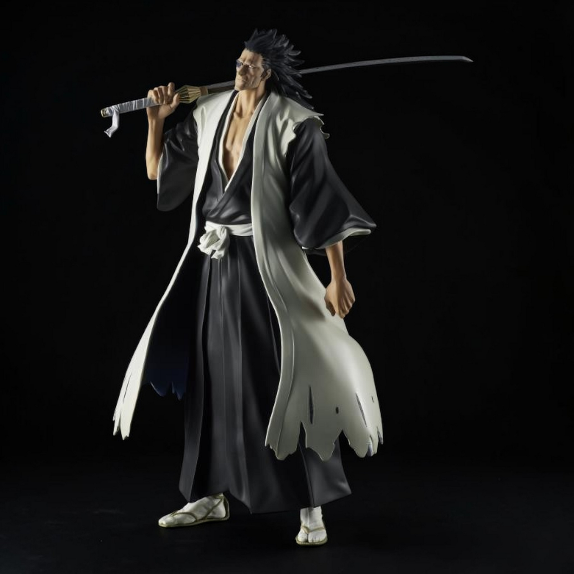 Figure of a character in traditional Japanese attire holding a sword against a black background