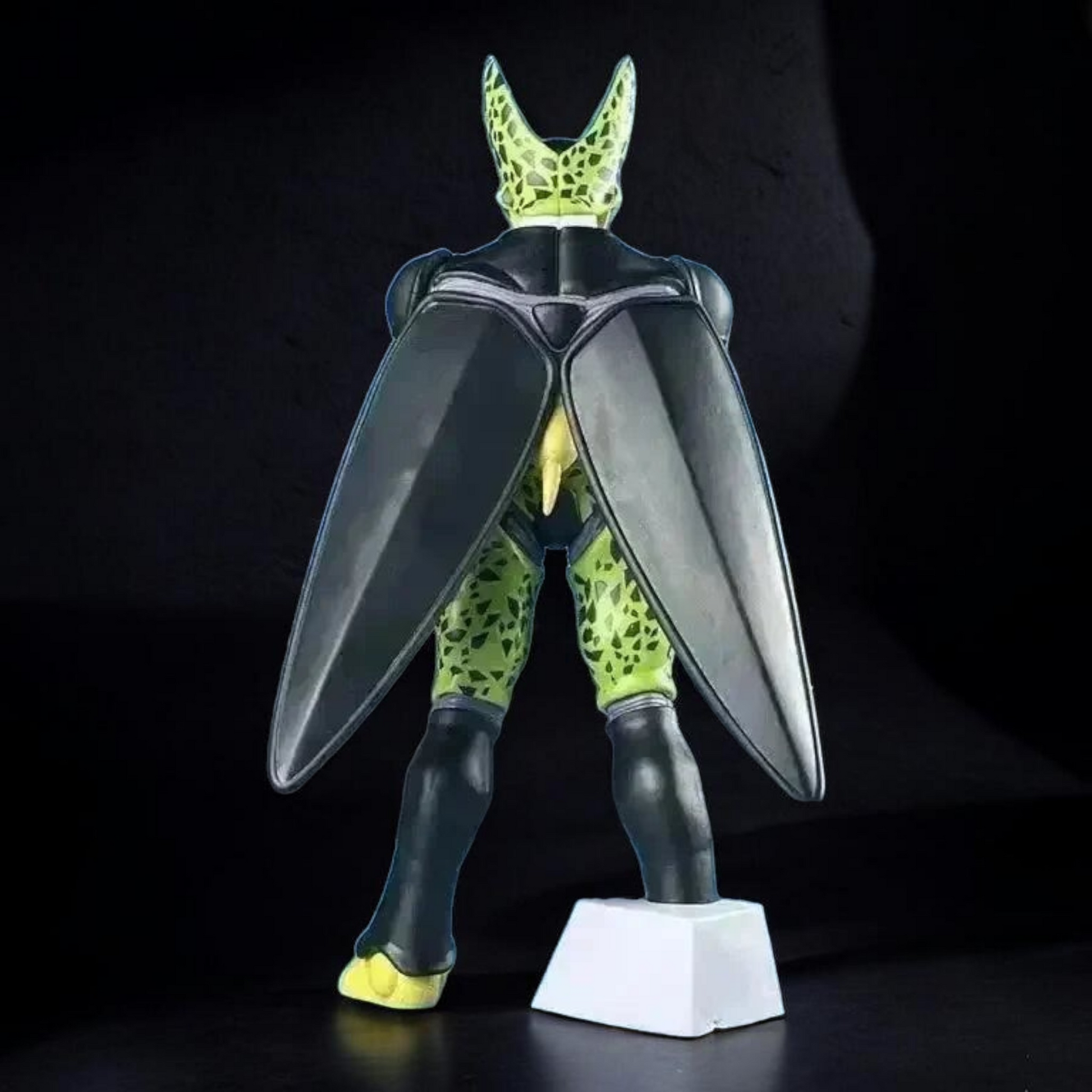 Toy figure of a character with large insect-like wings on a black background