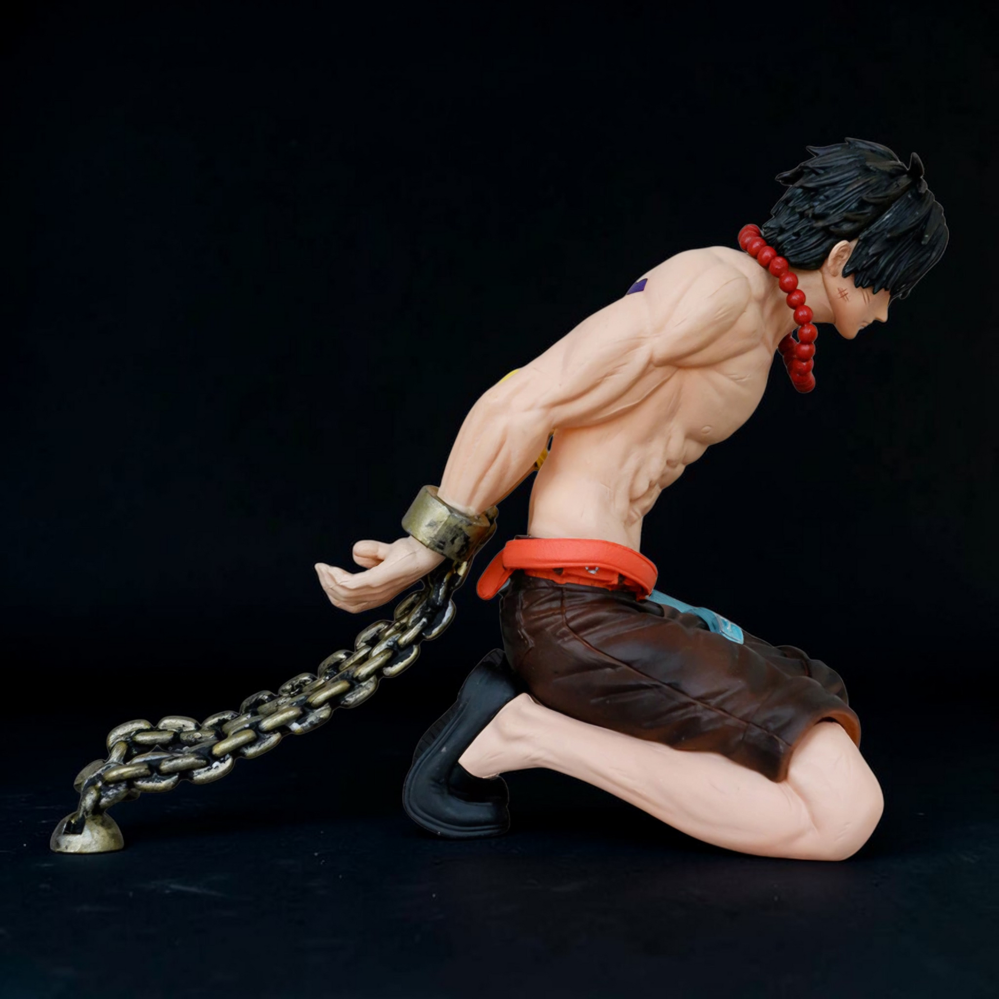 Action figure of a muscular character with chains and a dark background