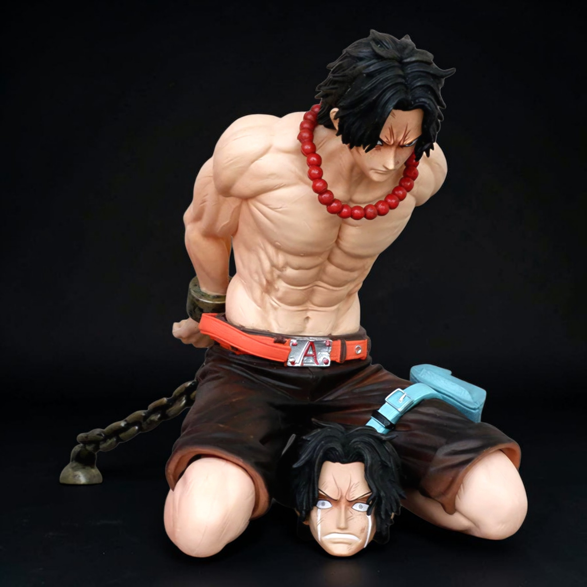 Muscular figure with red beads and black hair on a dark background