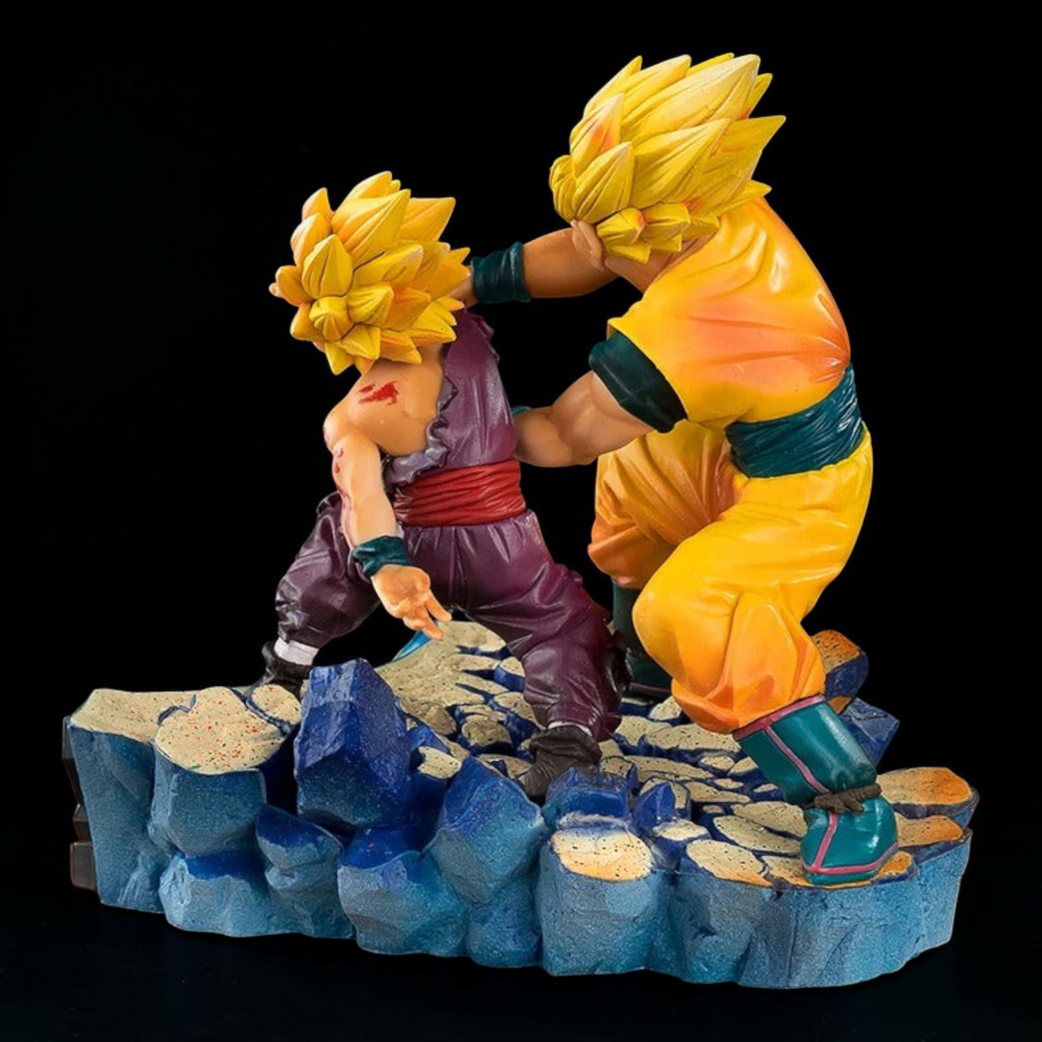 Two animated character figurines on a rocky platform with a black background