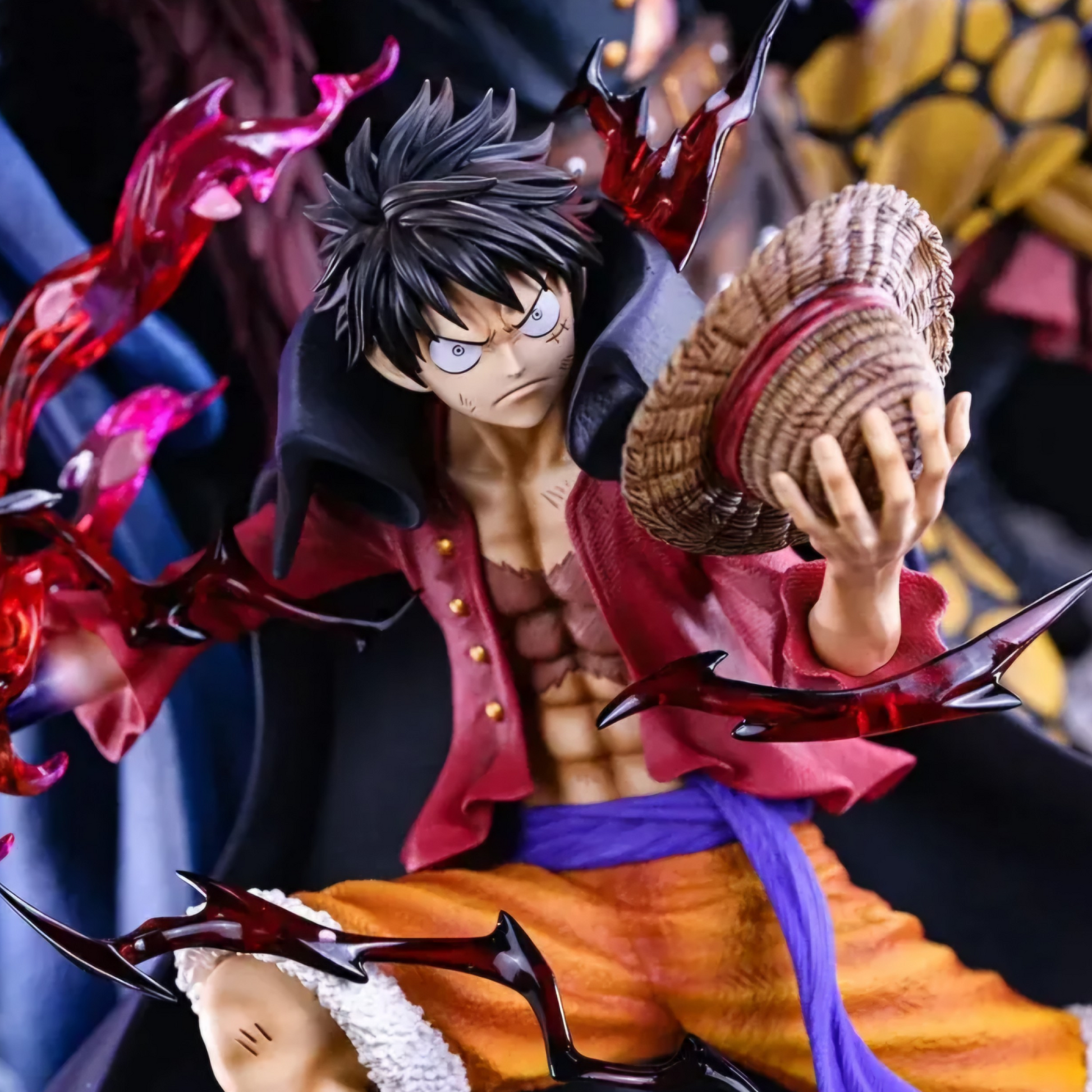 Anime character figurine with a red hat and colorful outfit, holding a small figure.