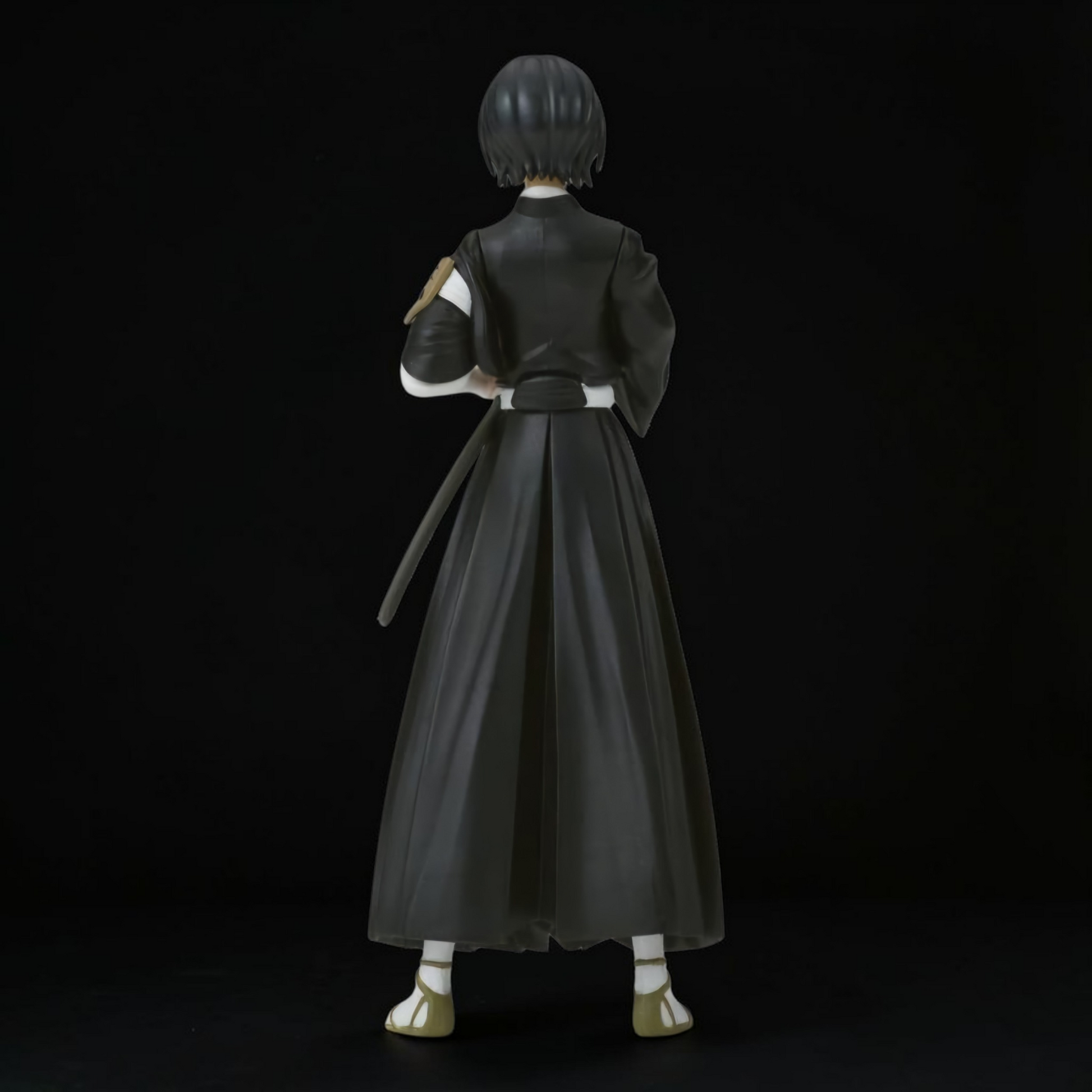 Figure of a character in a black outfit with a long skirt on a black background