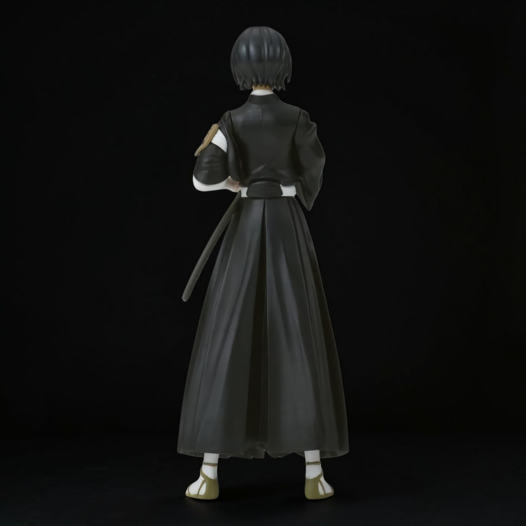 Figure of a character in a black outfit with a long skirt on a black background