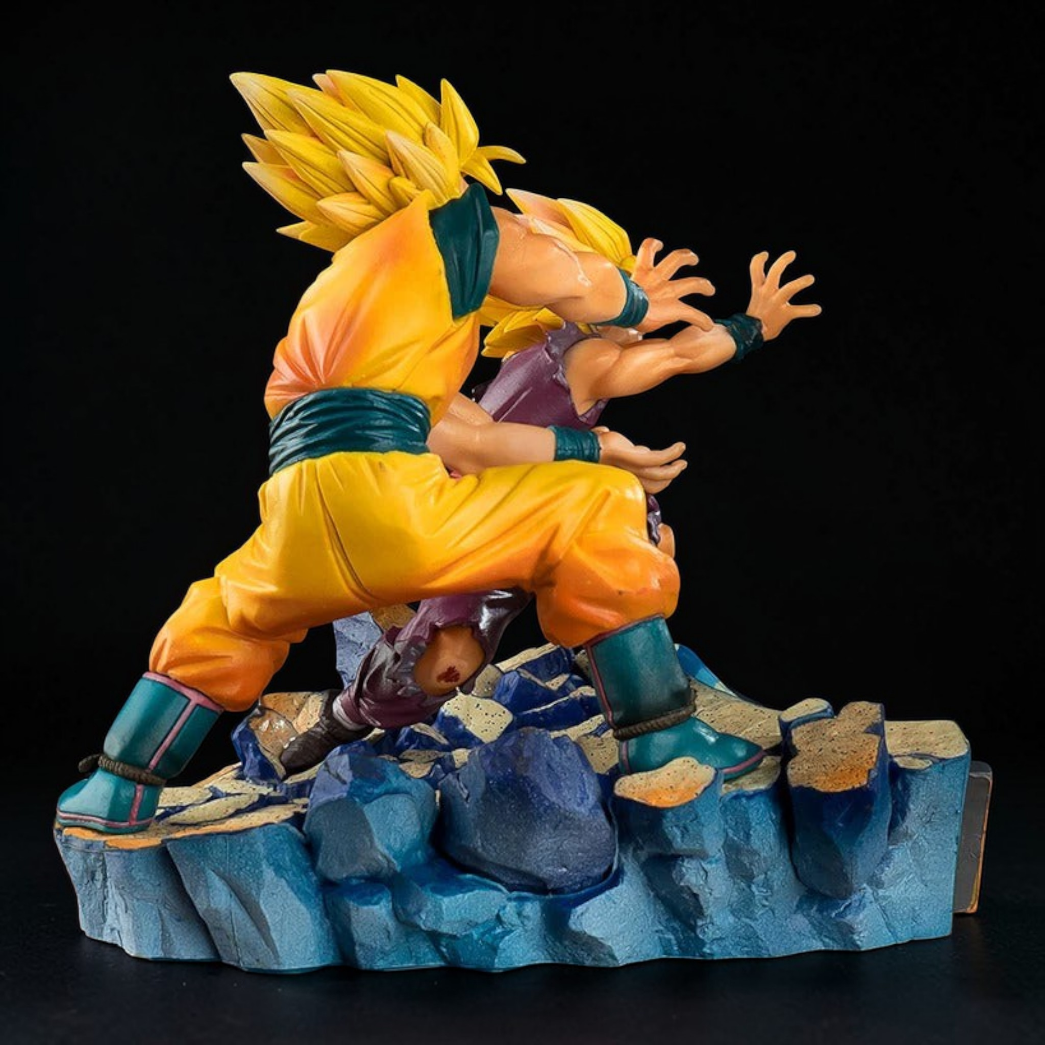 Action figure of a character in orange and blue outfit on a rocky platform with a black background
