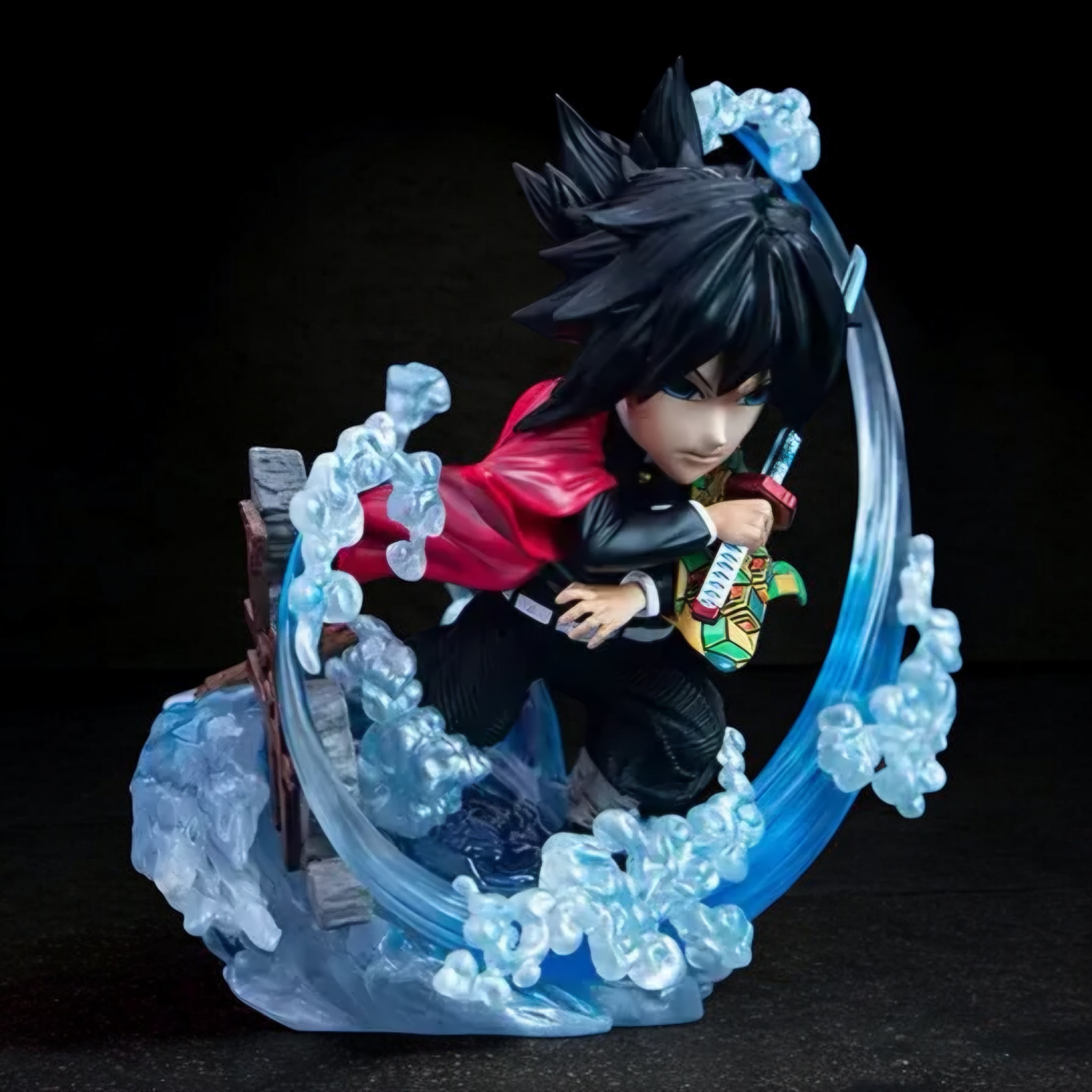 Anime character figurine with black hair and red jacket surrounded by blue energy on a dark background