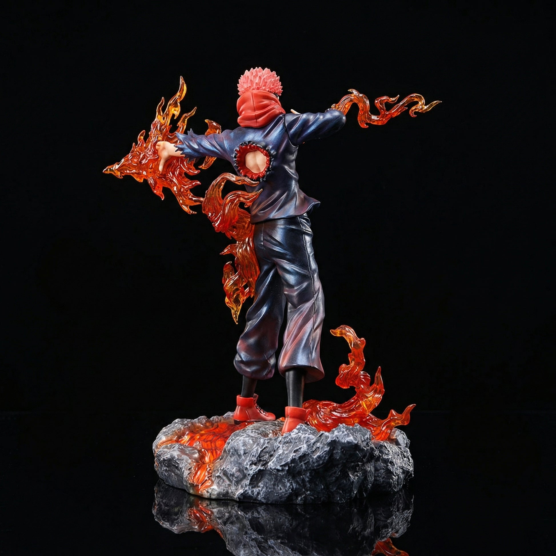 Statue of a character with flames, standing on a rock, against a black background