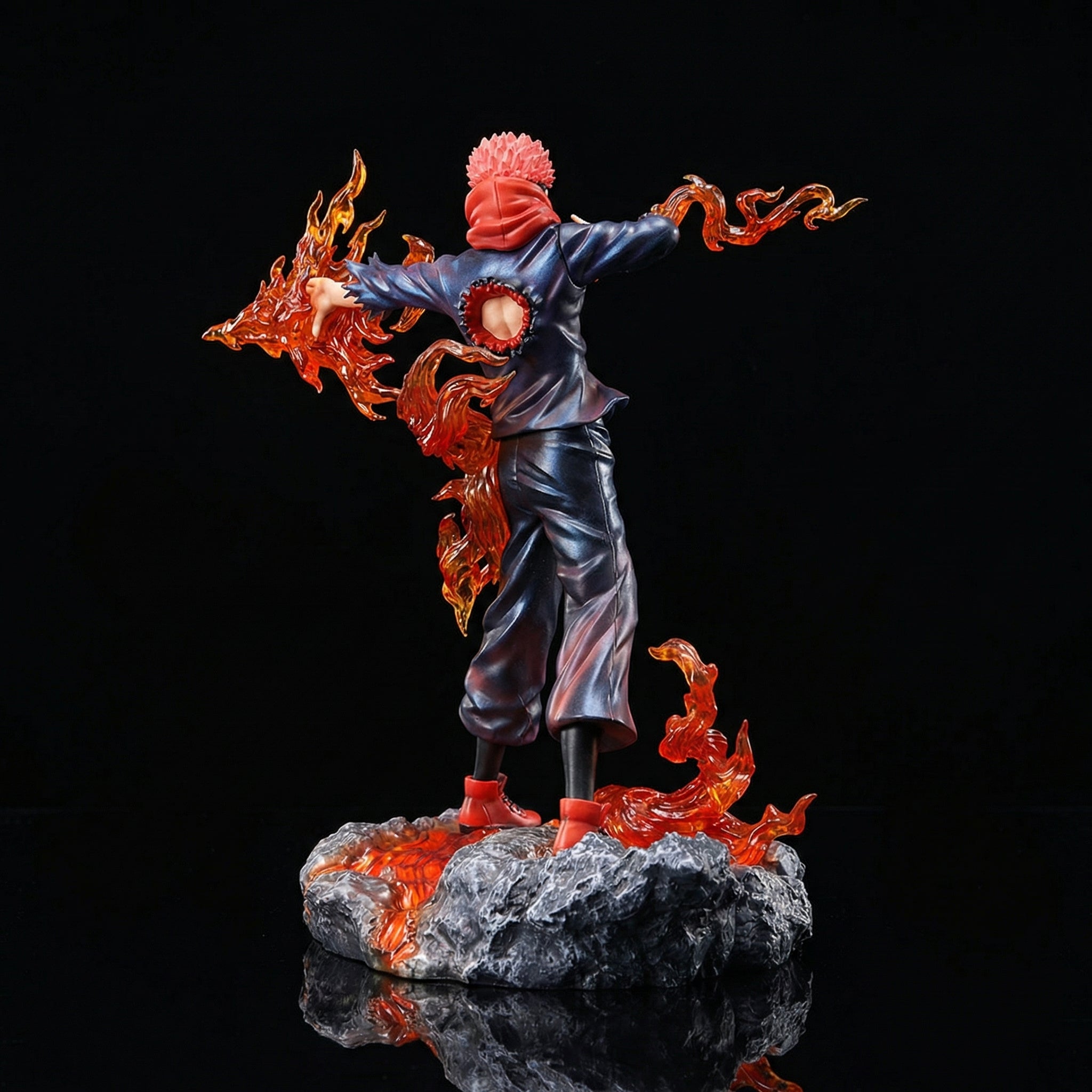Statue of a character with flames, standing on a rock, against a black background