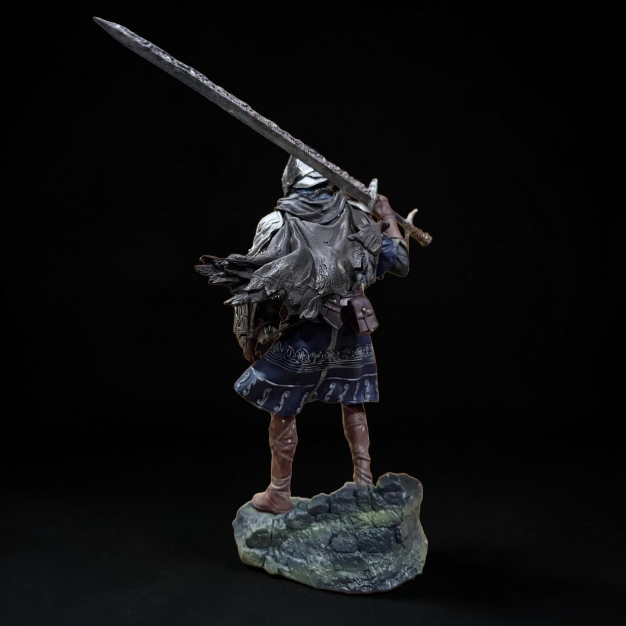 Statue of a warrior holding a sword on a dark background